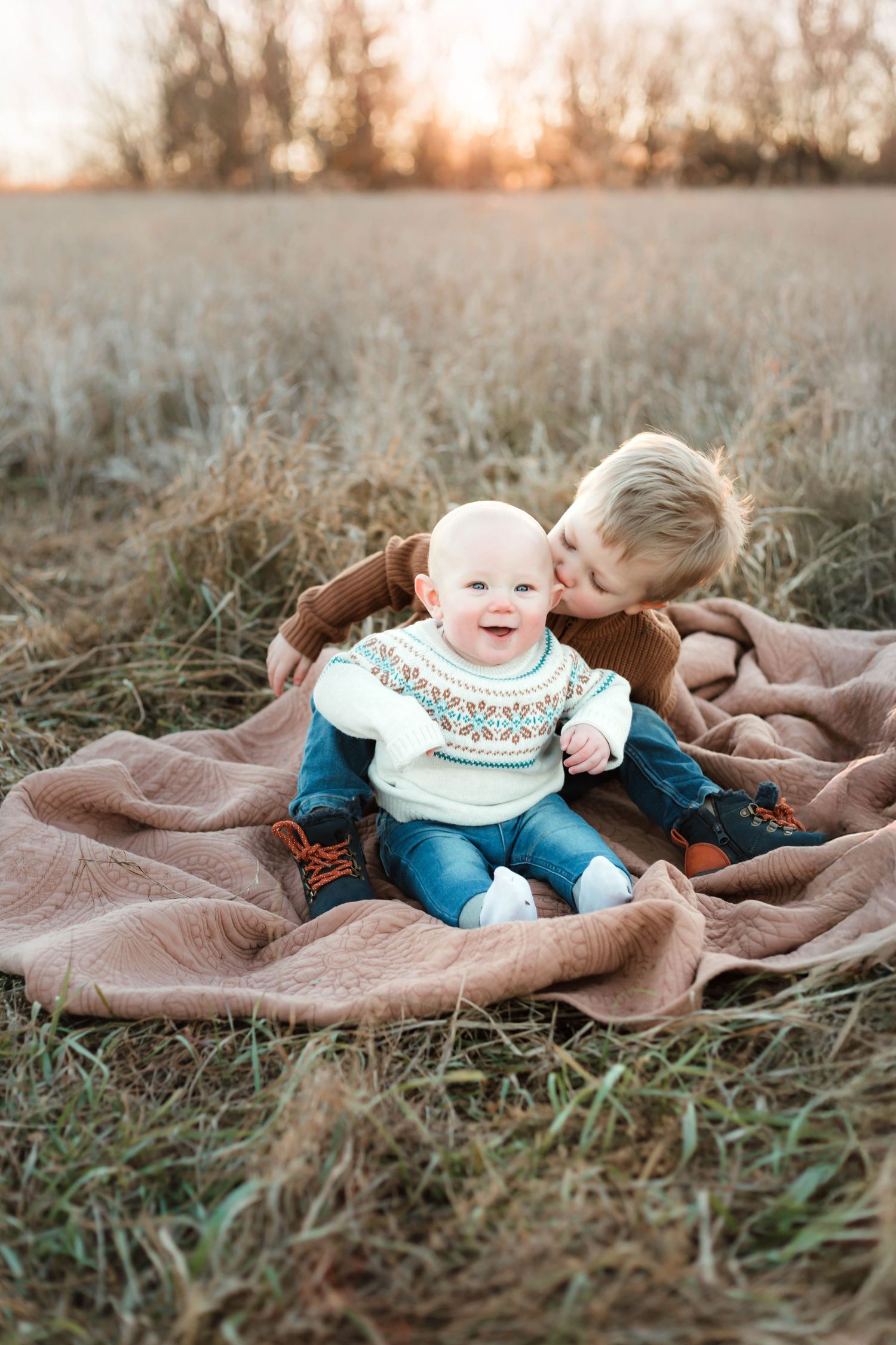 Brothers cuddling in grassy field Southeast Minnesota