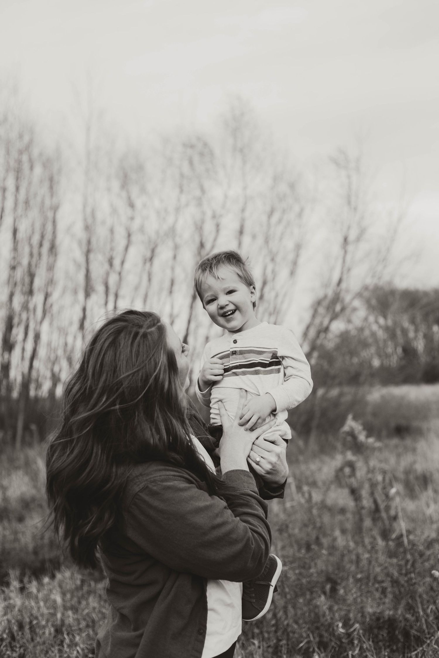 Mom holding child and tickling in field in Southeast Minnesota