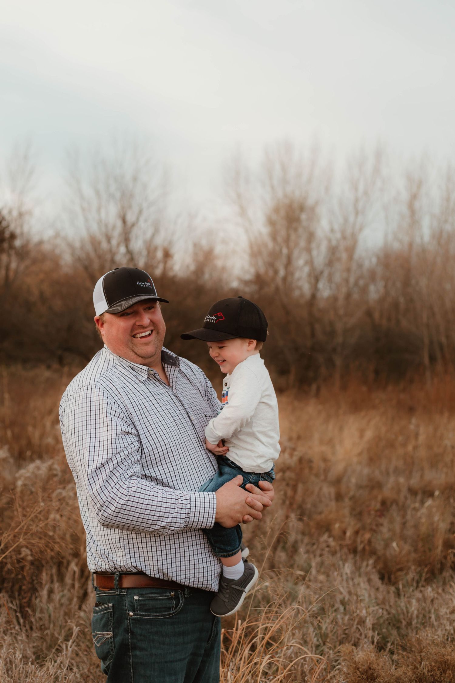 Dad and son hugging in grassy field Southeast Minnesota