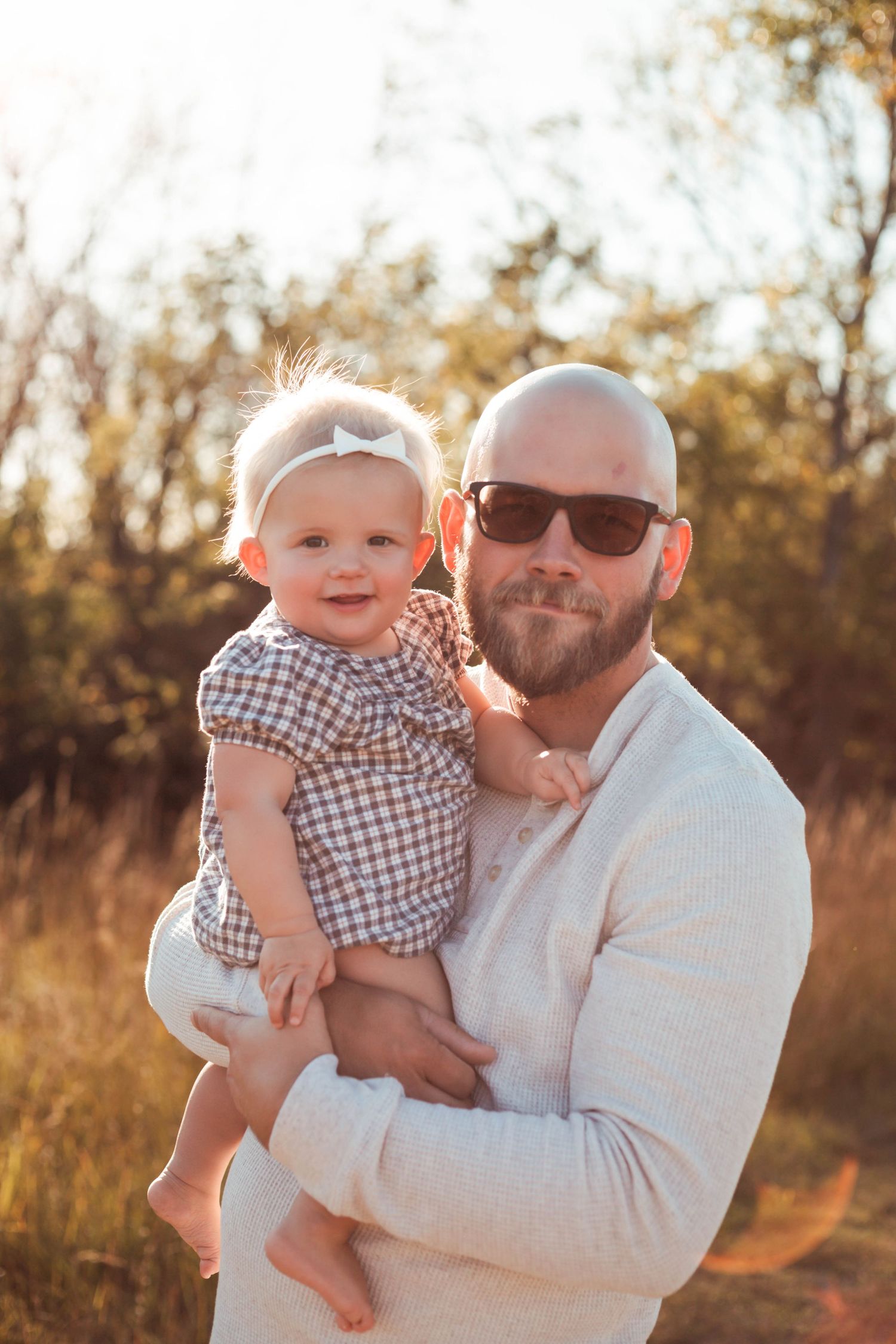 Father and baby in sunny, grassy field Southeast Minnesota