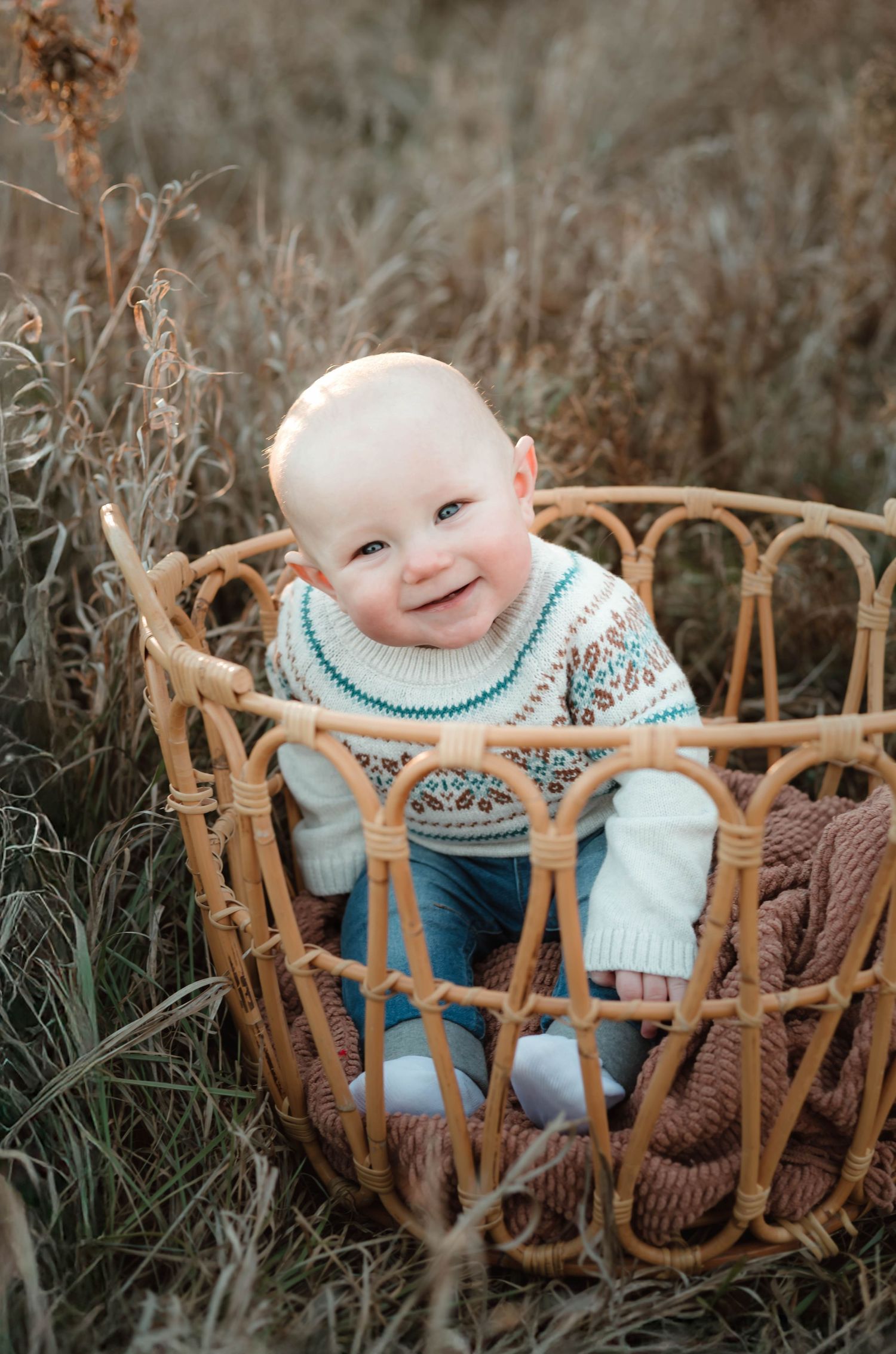 Baby in a basket smiling in grassy field Southeast Minnesota