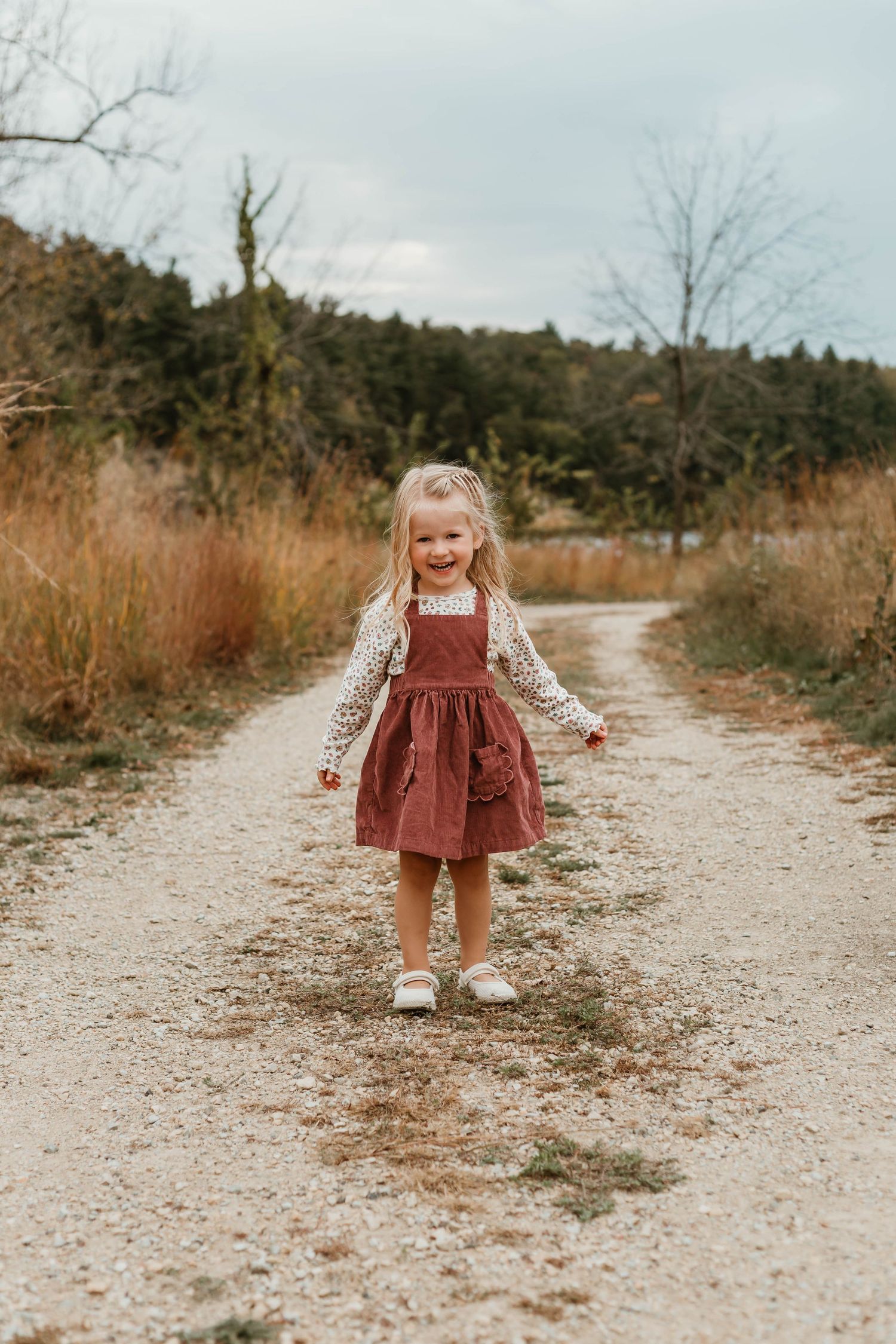 Little girl walking on gravel in grassy field Southeast Minnesota