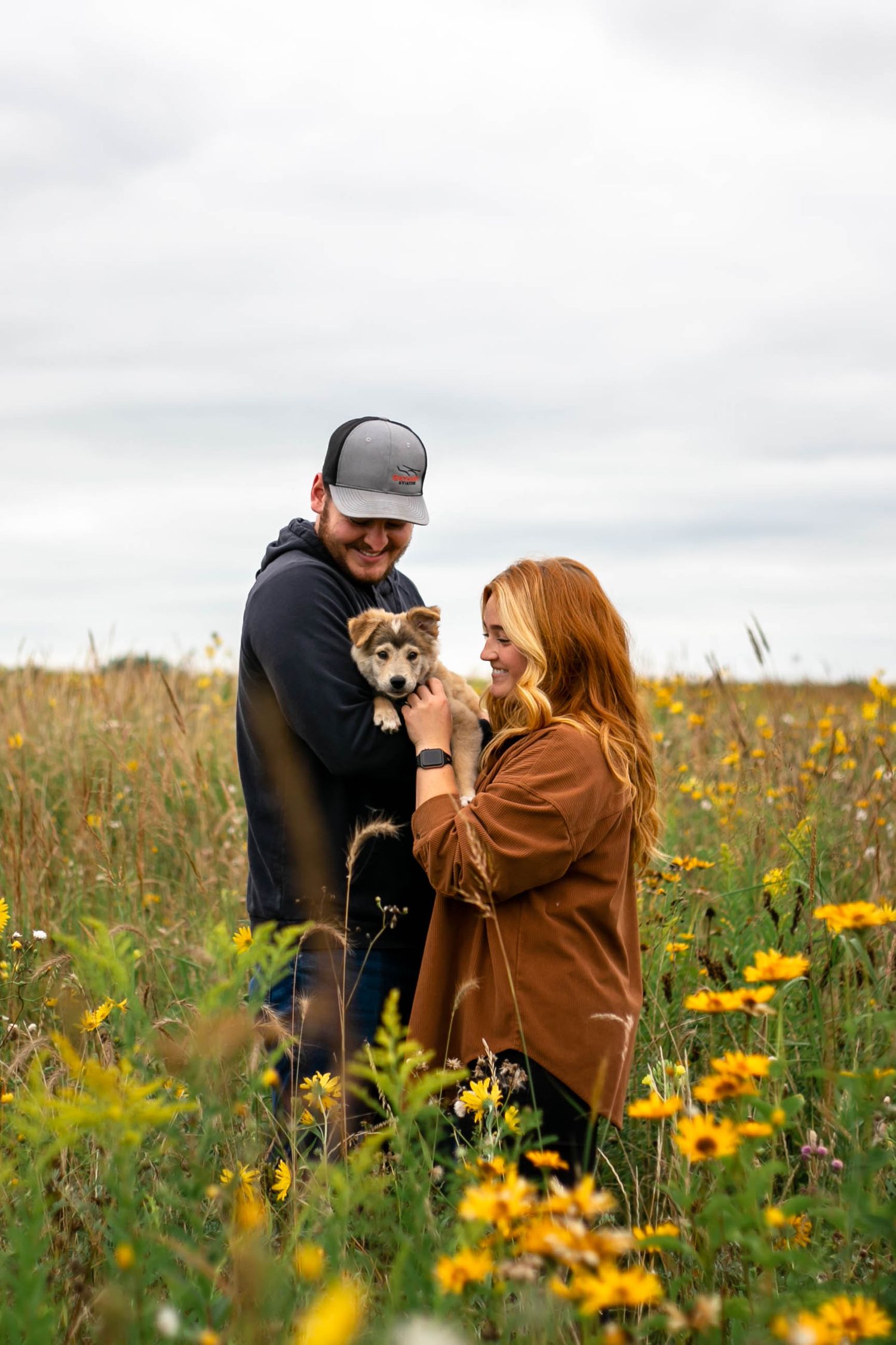 couple with puppy in field southeast minnesota