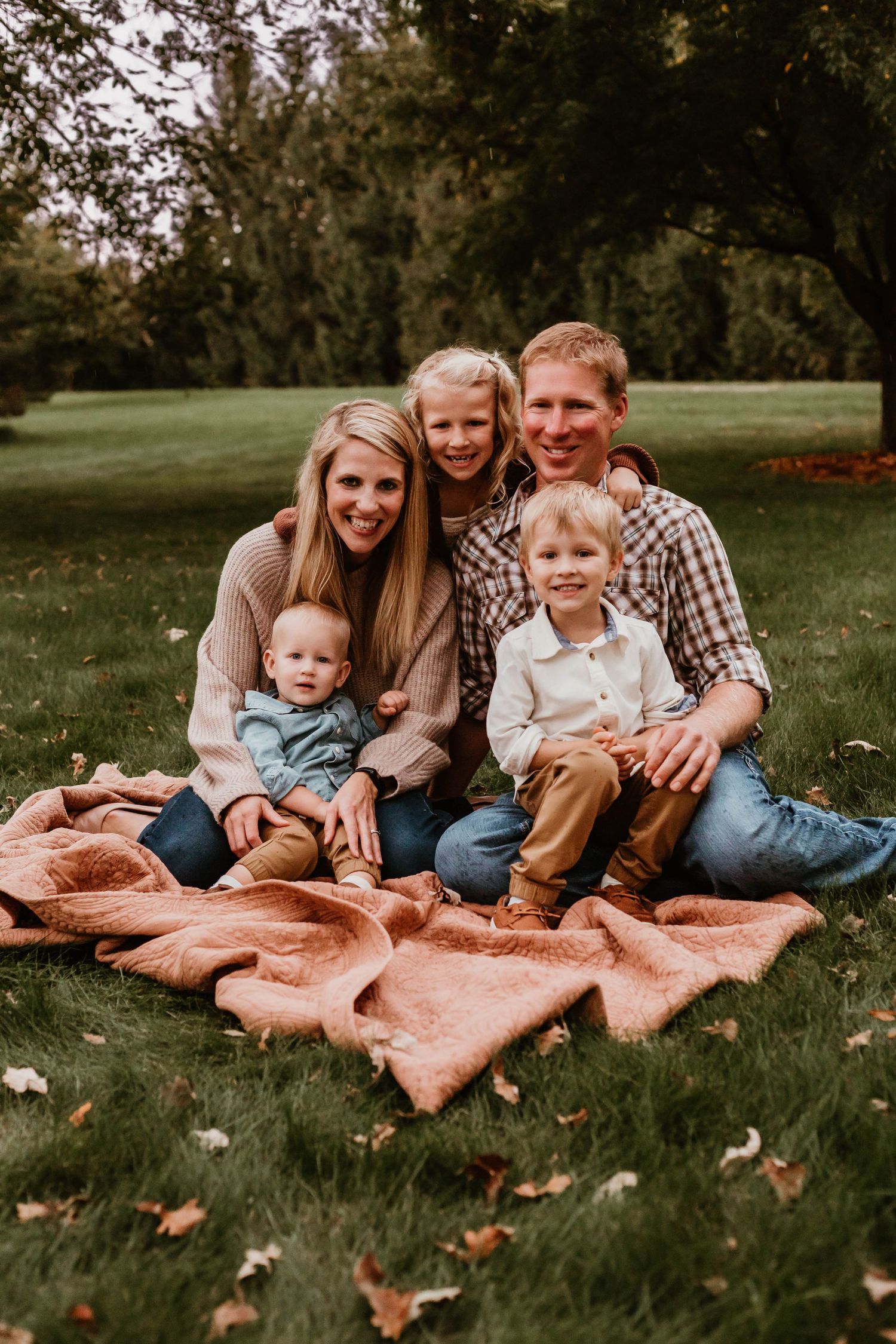 Family of 5 cuddling in grassy field Southeast Minnesota