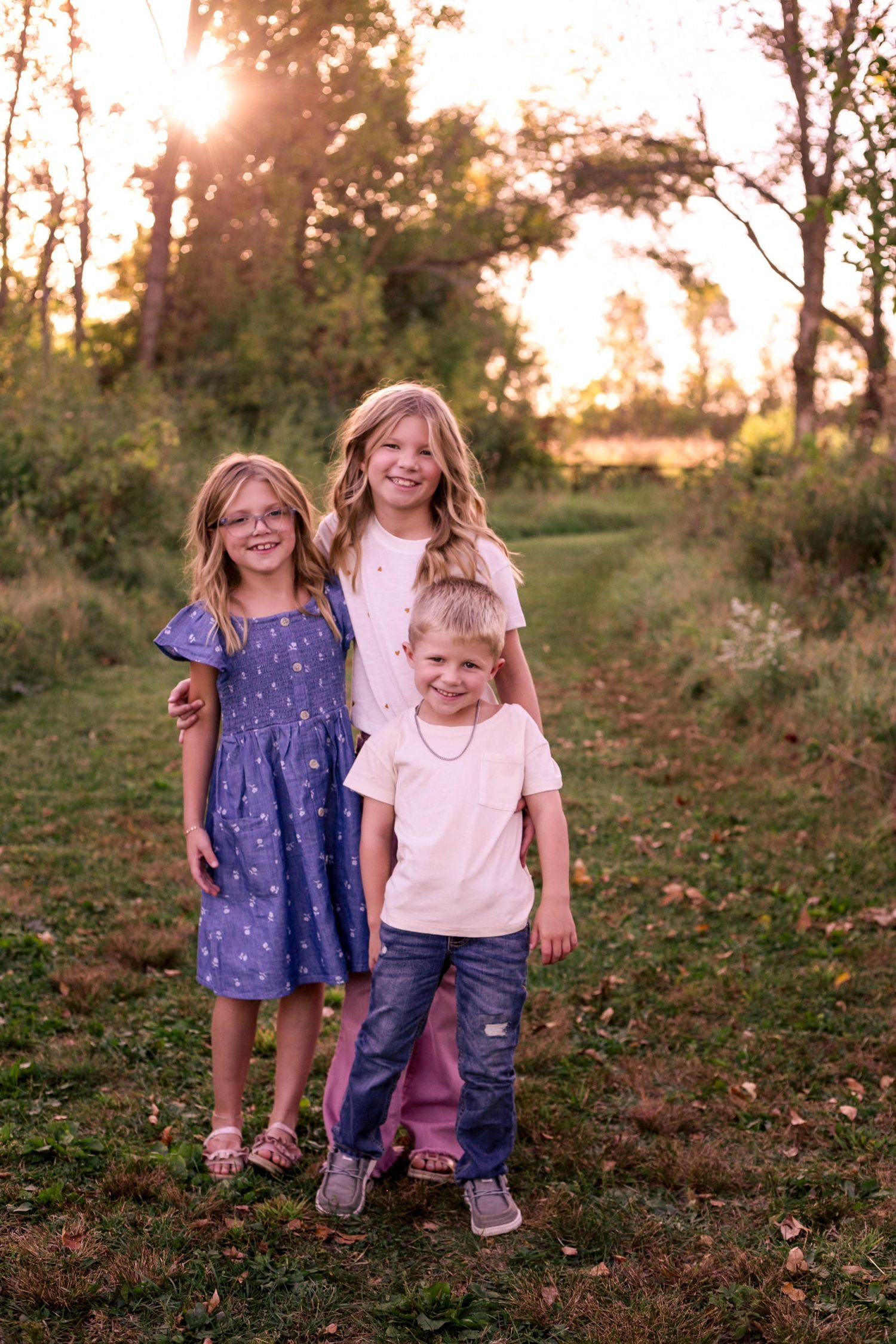 Three siblings standing on grass trail in Southeast Minnesota