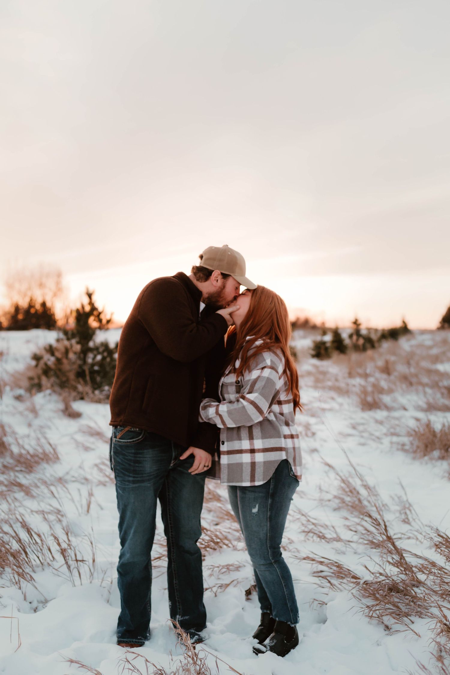 Couple playing in snowy field southeast minnesota