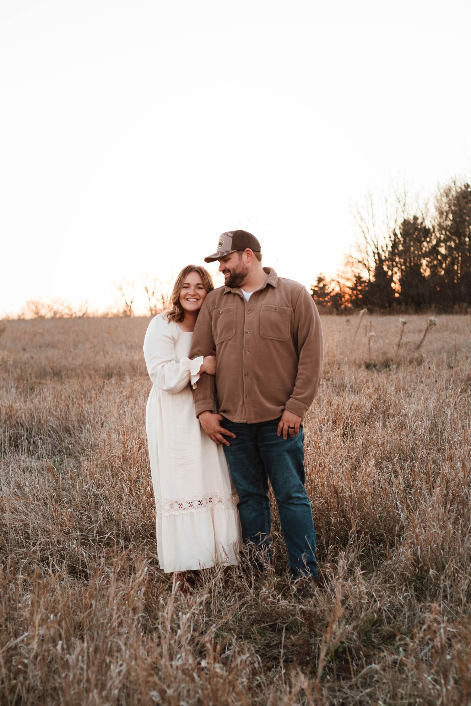 Couple holding each other in grass field southeast minnesota