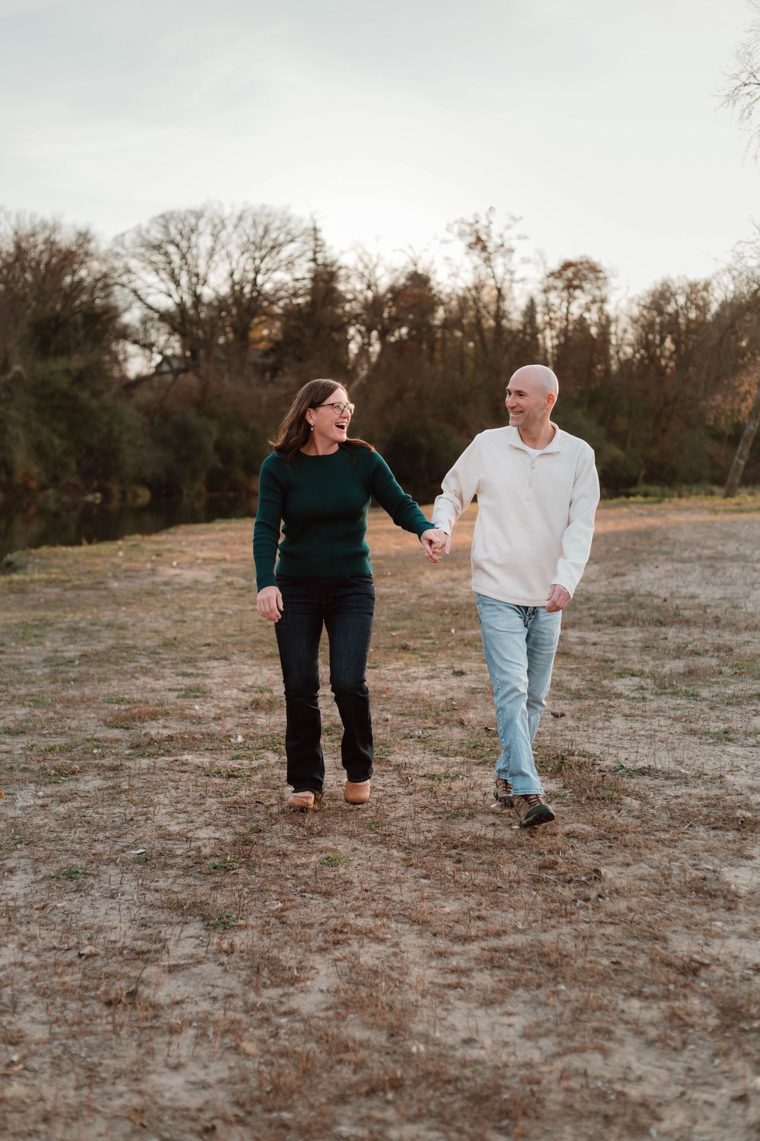 Couple holding hands in grass field southeast minnesota