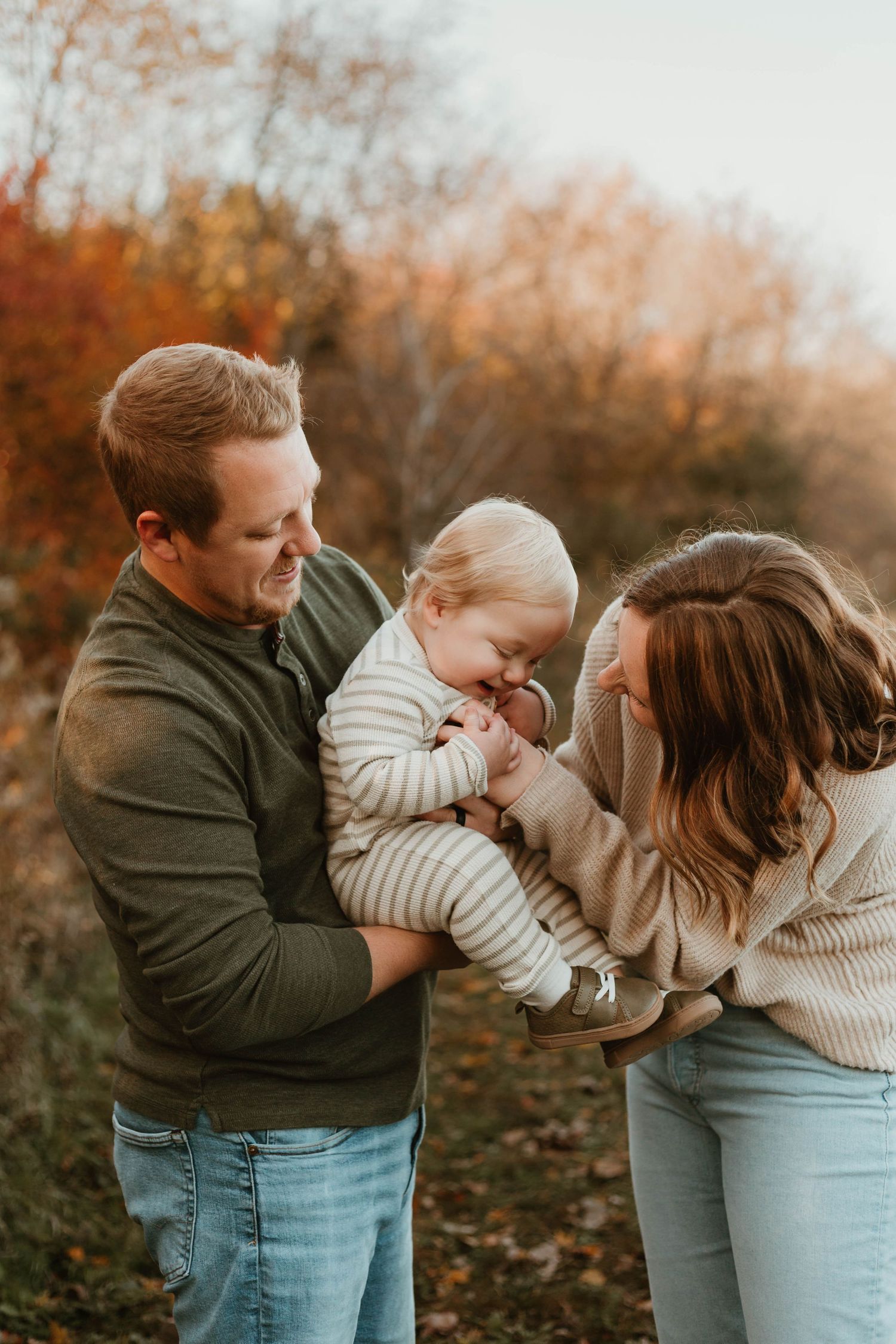 Family of 3 tickling in grassy field Southeast Minnesota