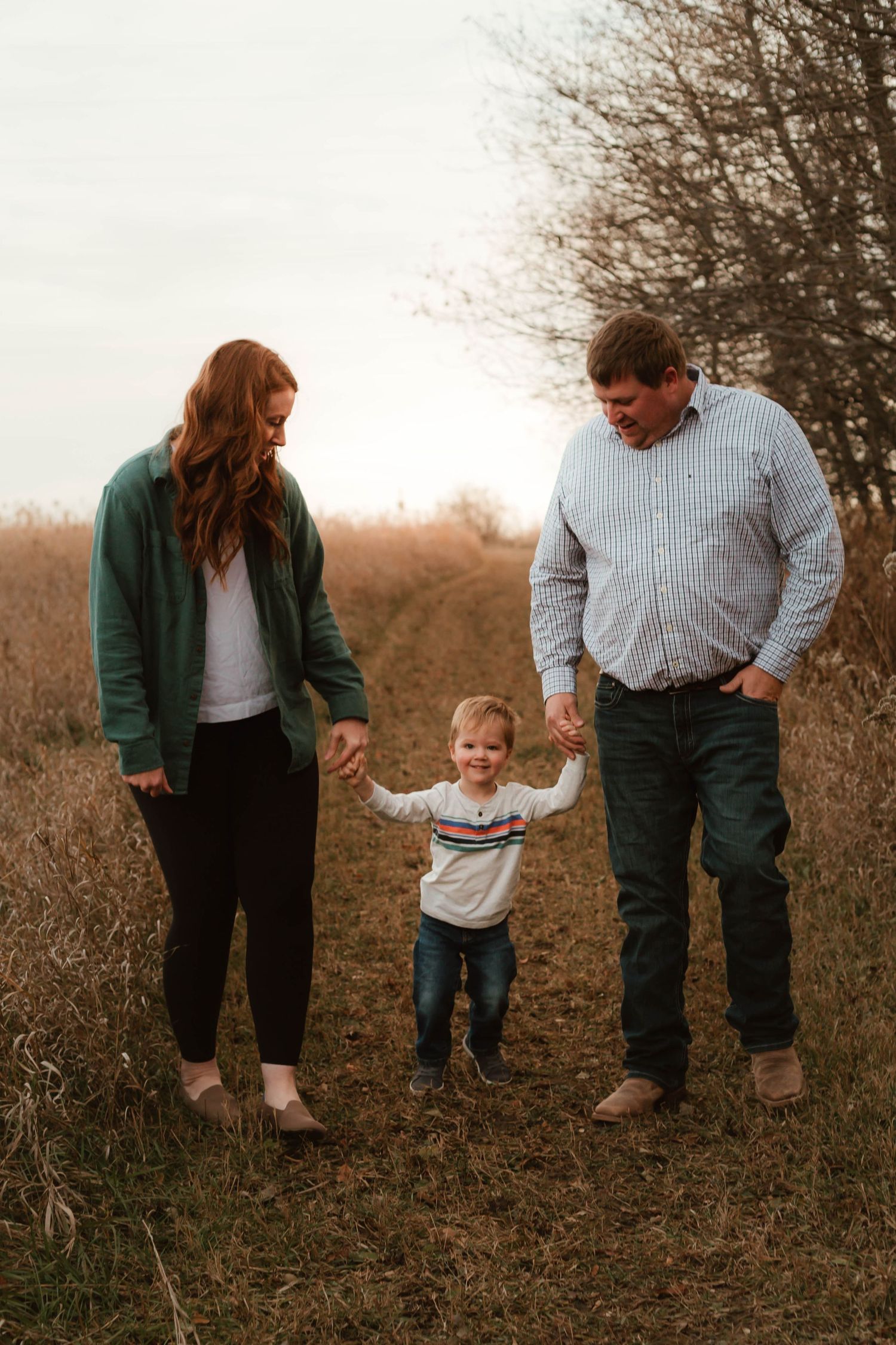Family of 3 walking field in grassy field Southeast Minnesota