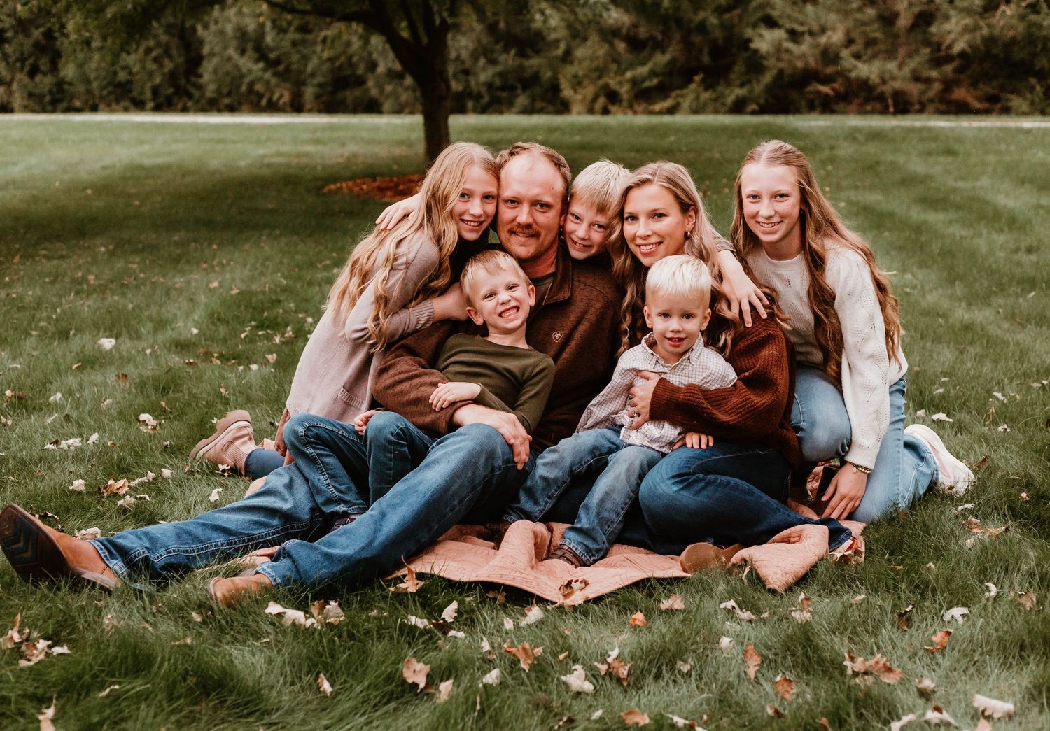Family of 7 cuddling in grassy field Southeast Minnesota