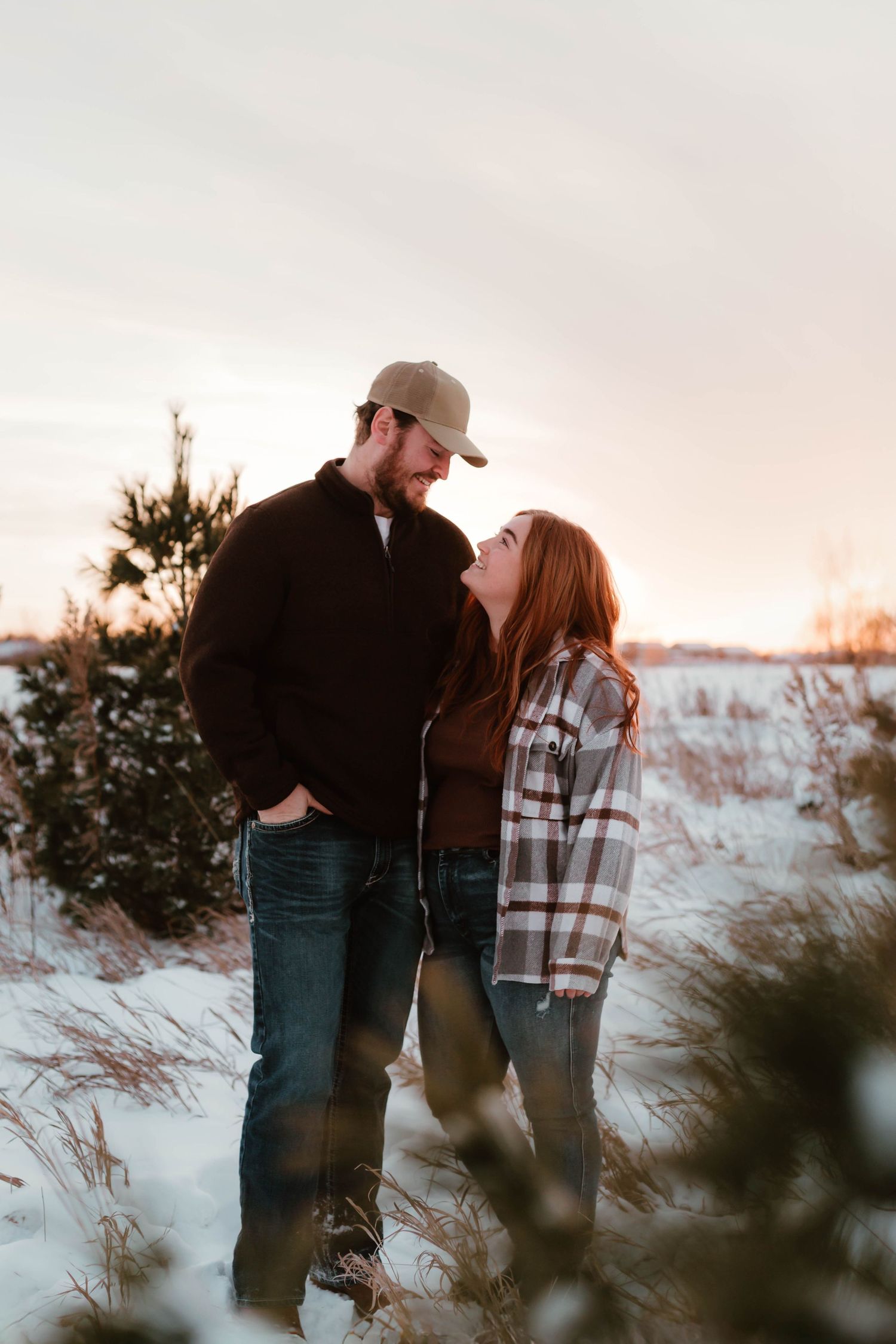 Couple playing in snowy field southeast minnesota