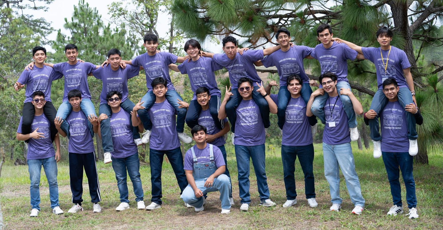 Energetic outdoor group portrait of students posing together with playful stacked poses.