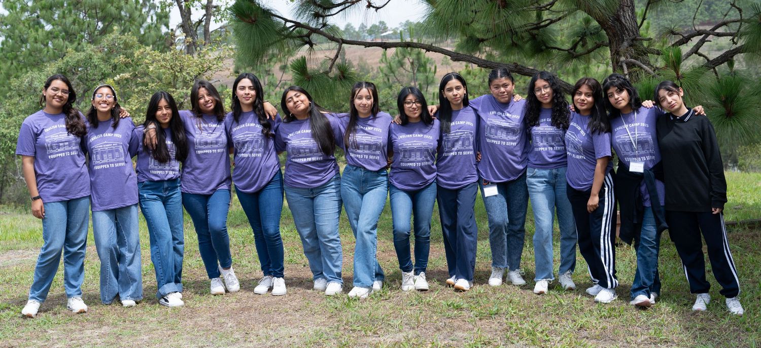 Outdoor group portrait of students standing together in matching shirts during a school event.