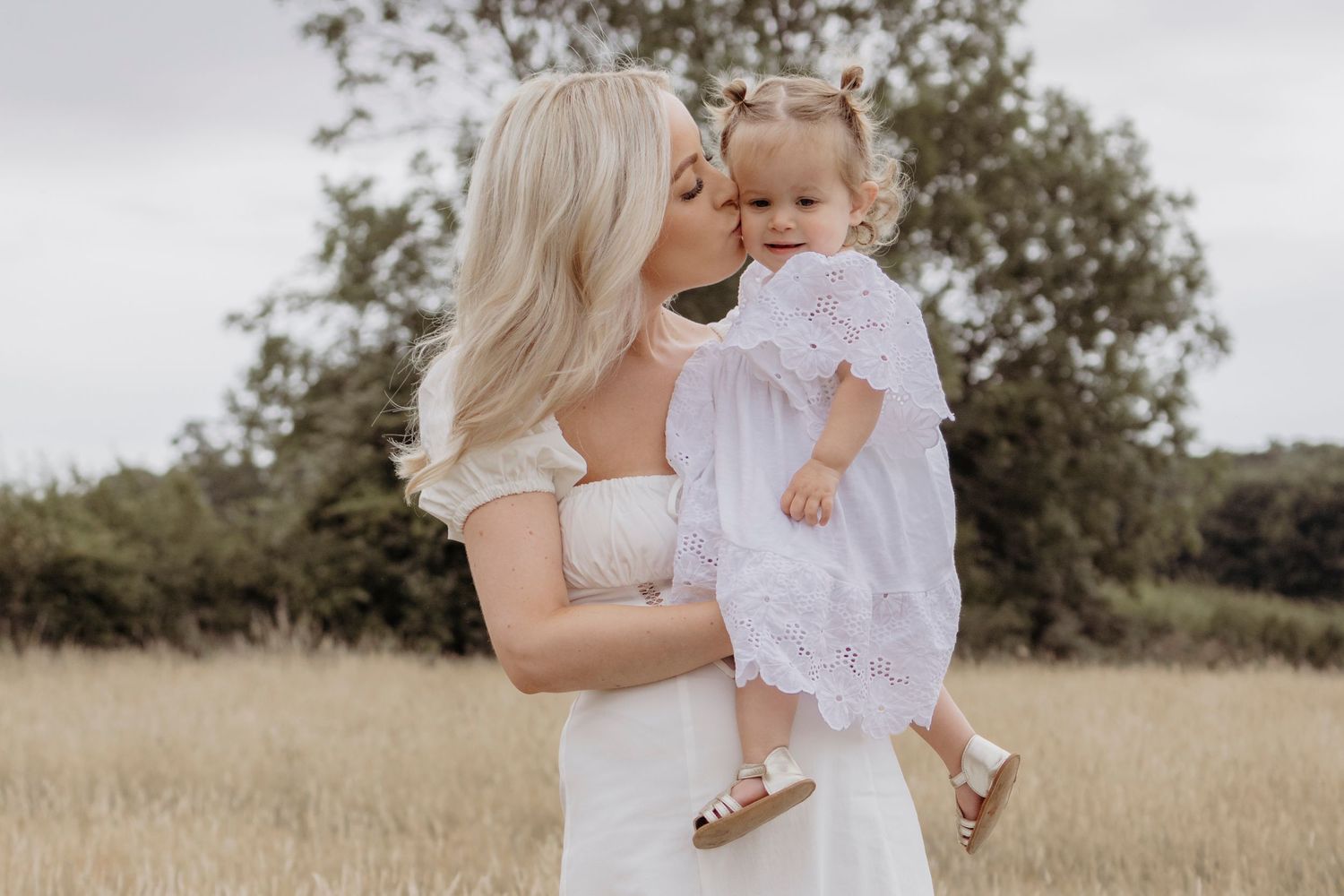 Sweet family moments captured in a field with soft natural lighting.