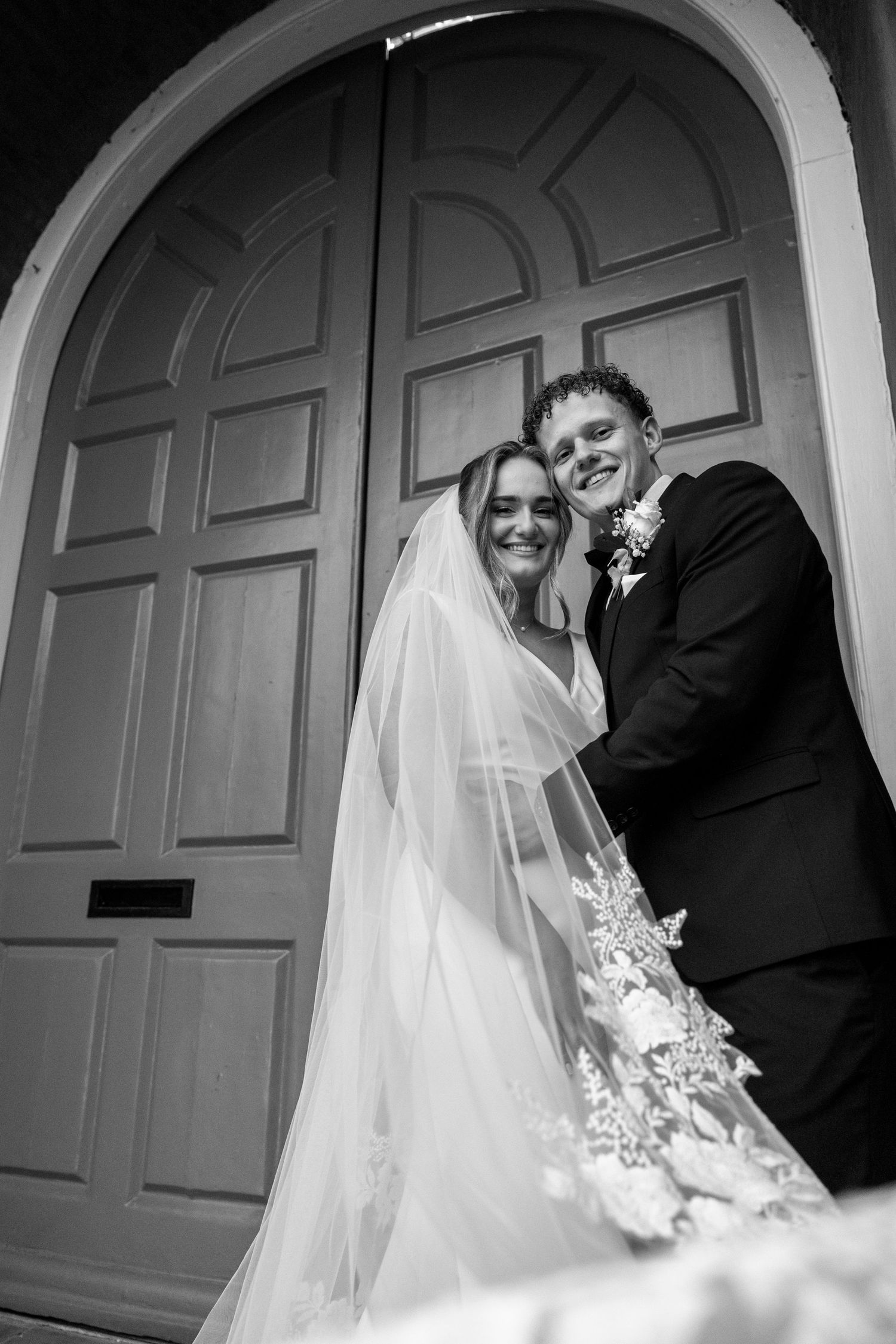 Series of wedding portraits showing joyful moments between newlyweds by a classic door.