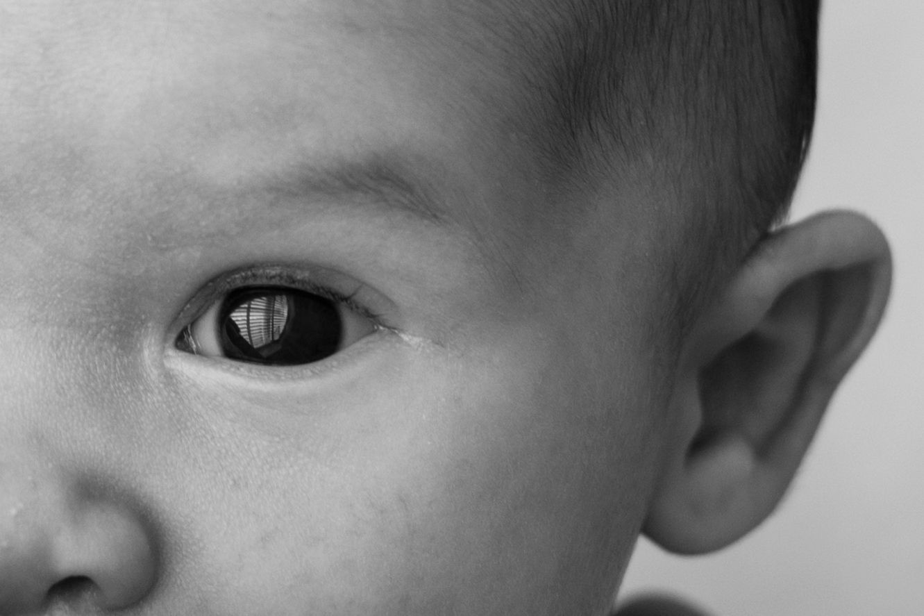 A series of close-up black and white photos showing a baby's facial expressions and features.