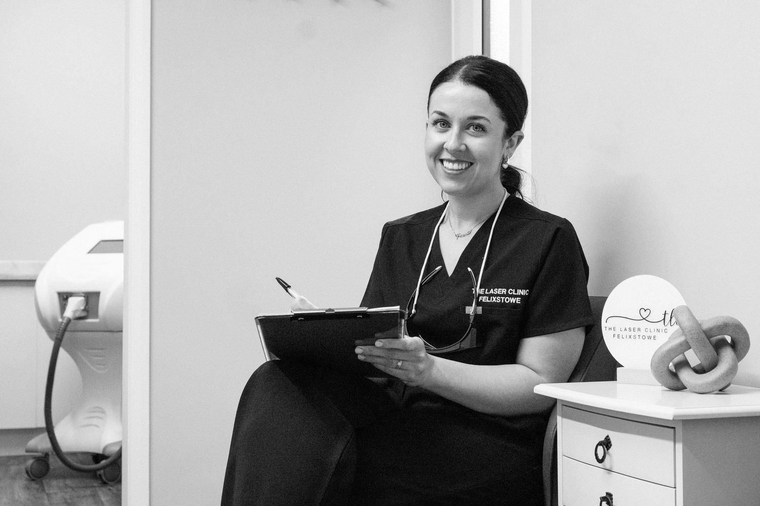 Medical professionals in white coats and scrubs working in a healthcare office setting.
