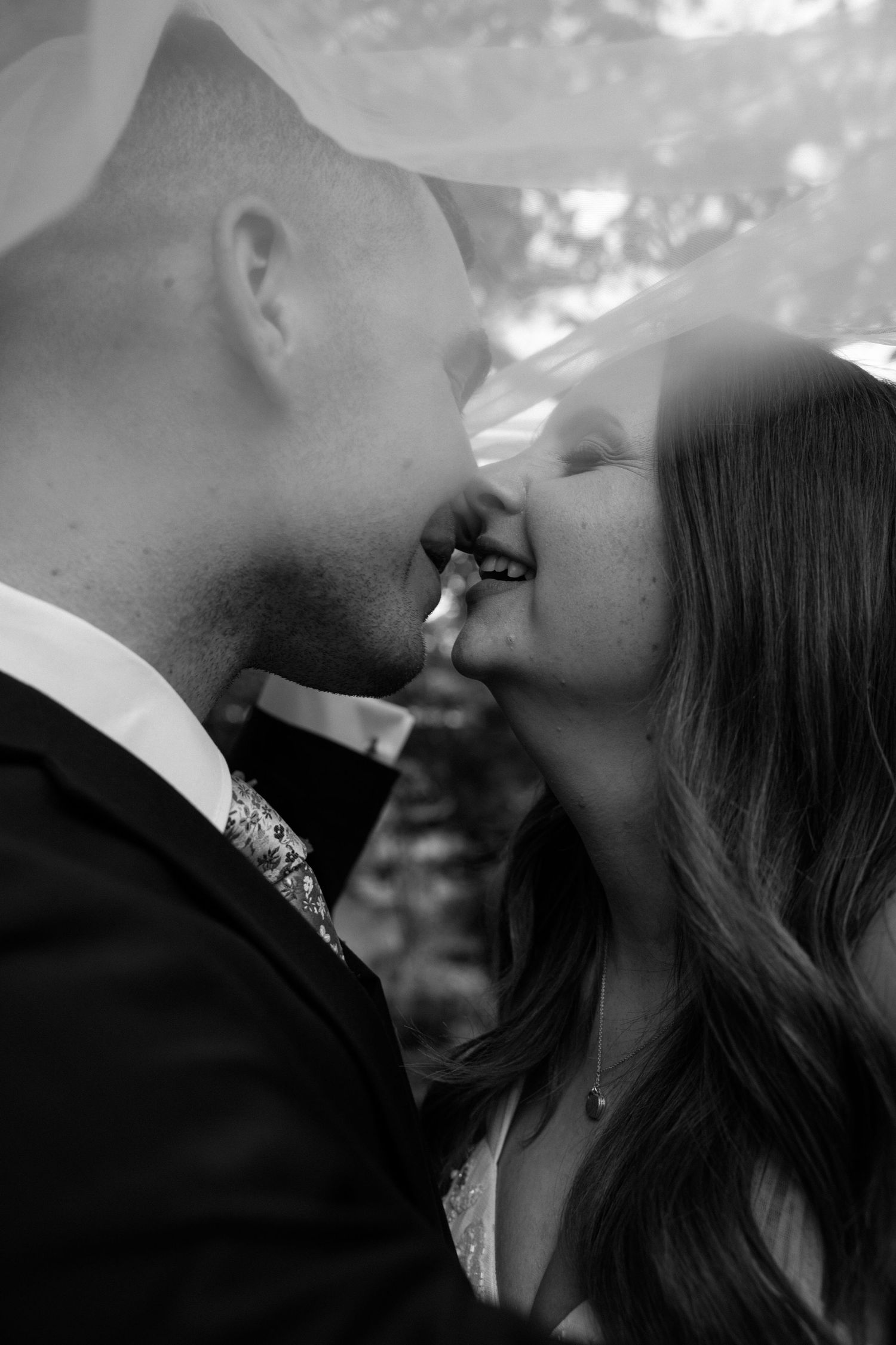 An intimate black and white close-up of a romantic moment between newlyweds.