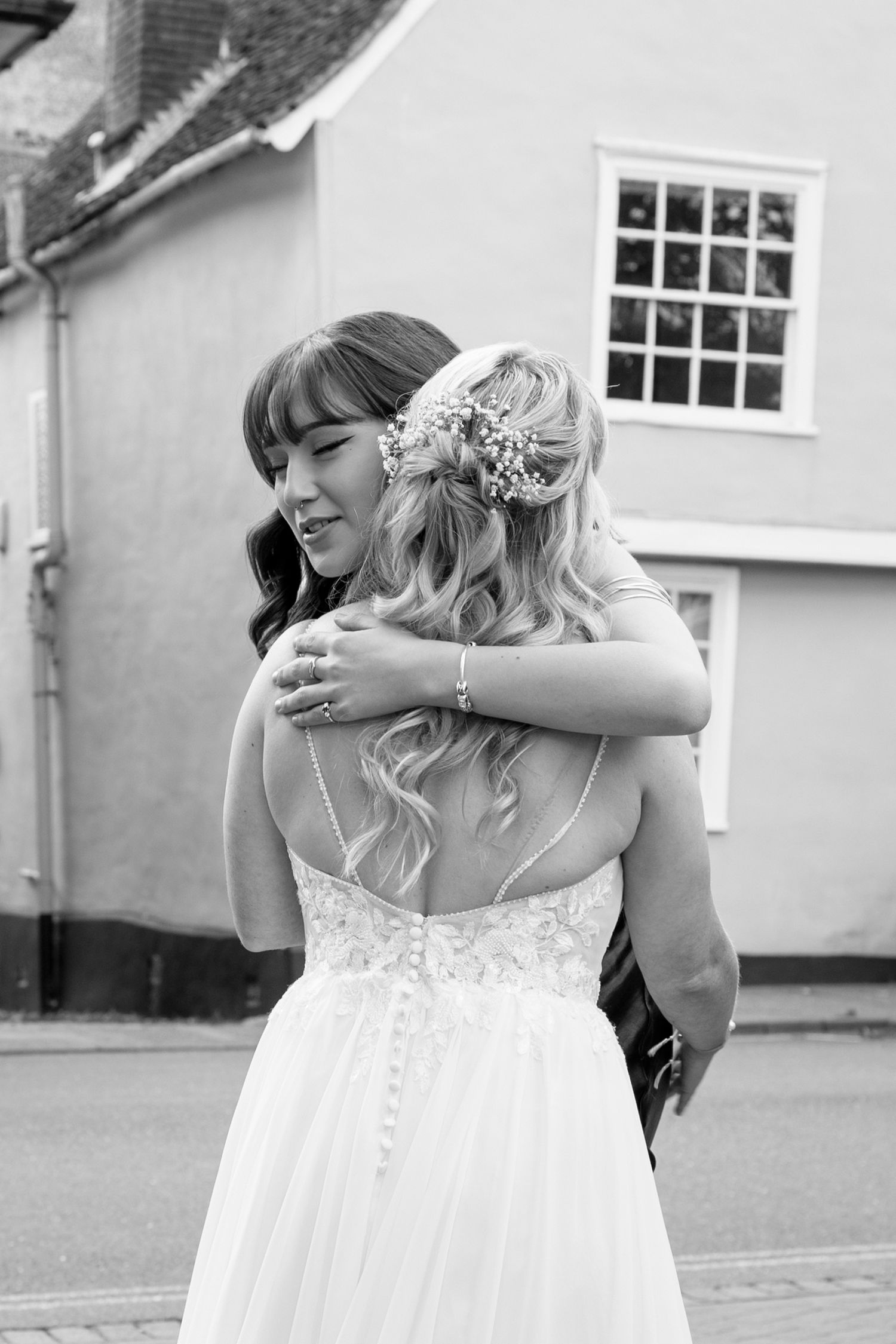 Two people share an emotional embrace during a wedding celebration.