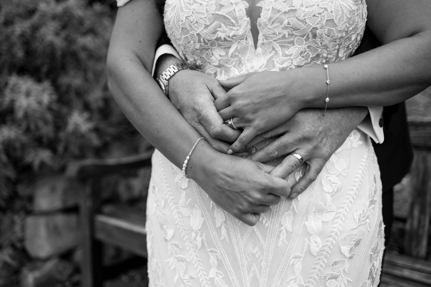 Close-up detail shot of intricate white lace wedding dress bodice with delicate beading and embroidery patterns.