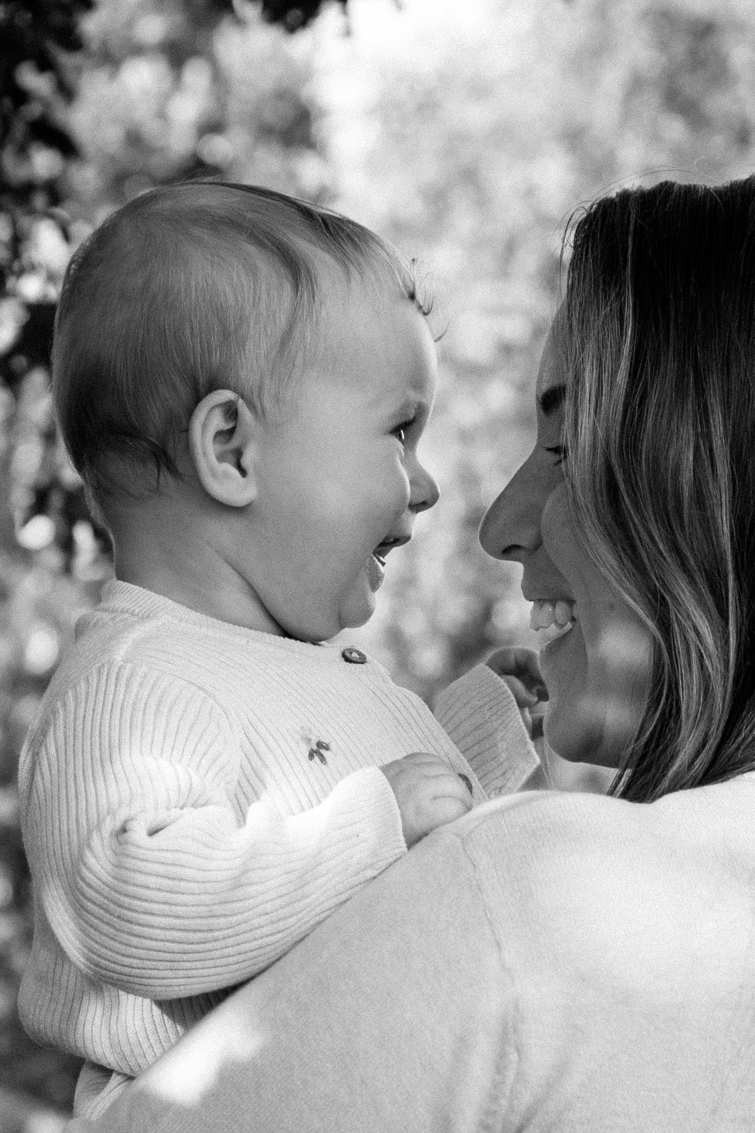 Black and white series of tender moments between parent and child in dappled sunlight.