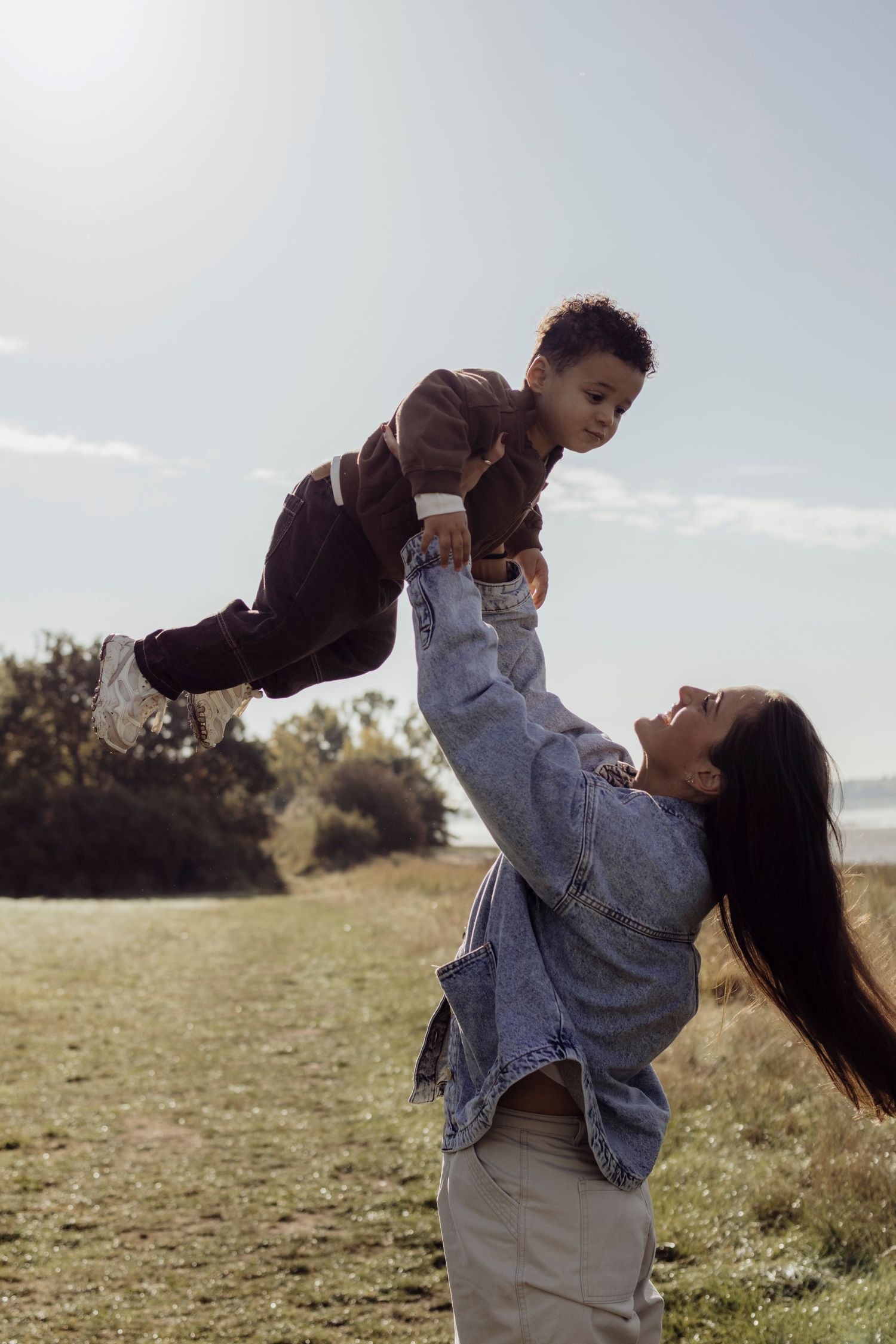 Joyful playful moments between parent and child in an open field.