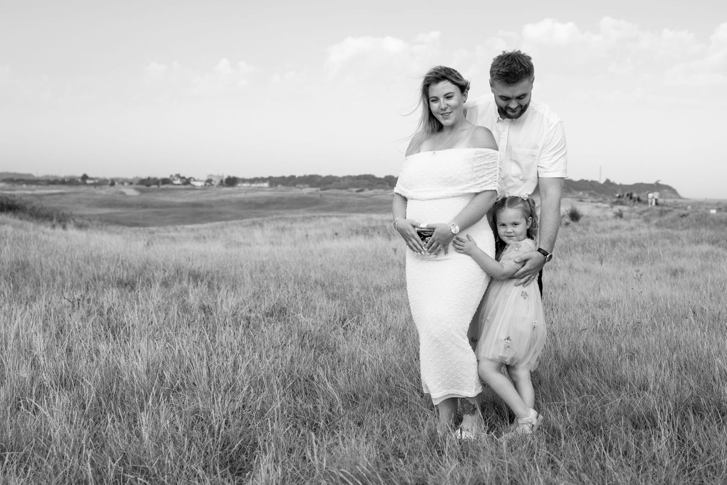 A black and white photo series showing people walking through a grassy field on a summer day.