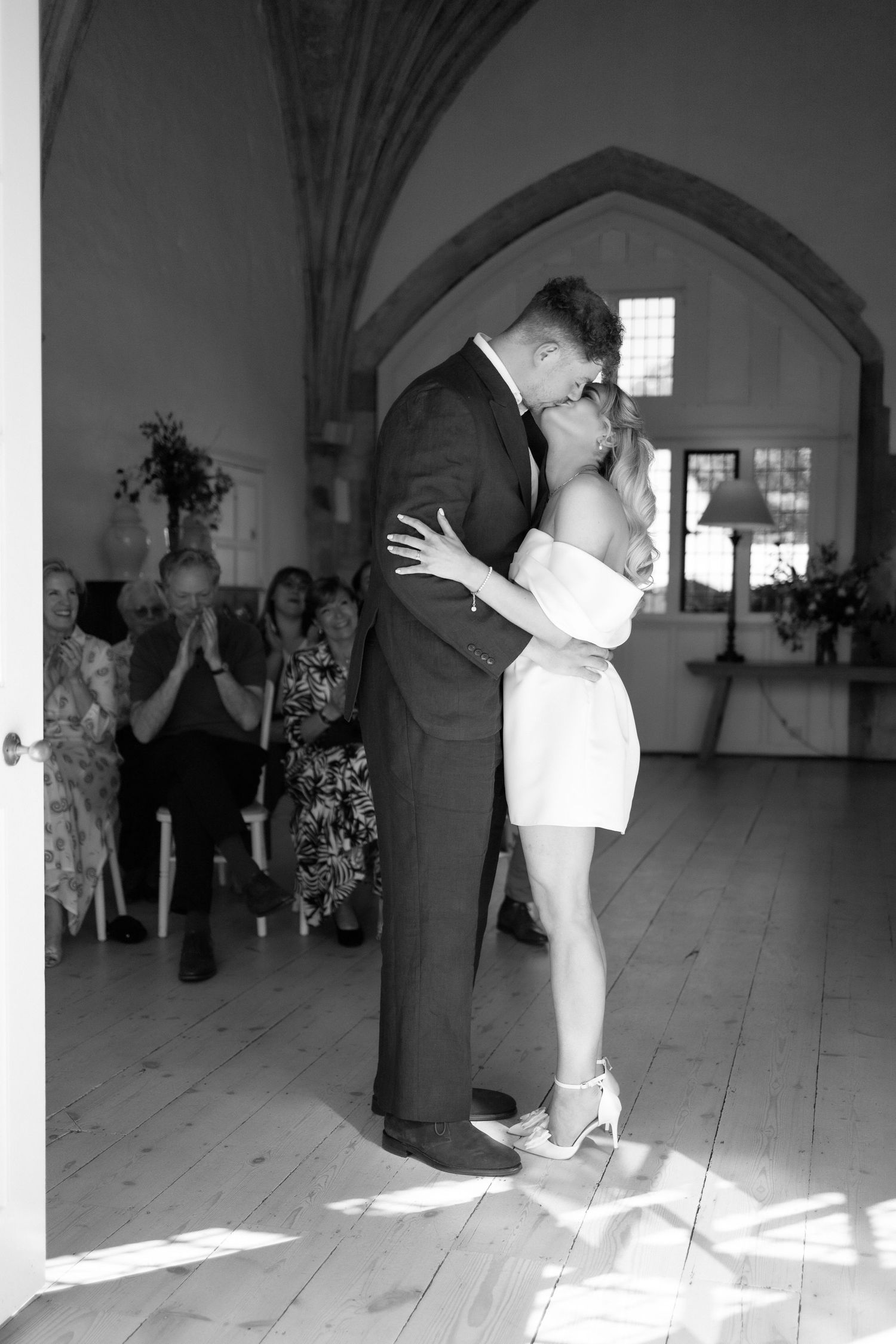 A black and white photo sequence shows dancers performing a dip move on a sunlit wooden floor.