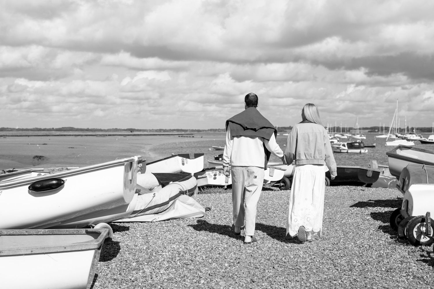 A series of black and white photos showing beach scenes with tents, boats, and coastal landscapes.