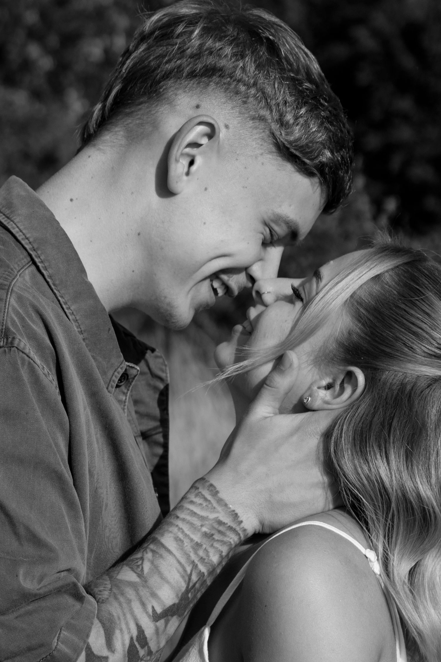 Black and white close-up of romantic couple sharing intimate moment.