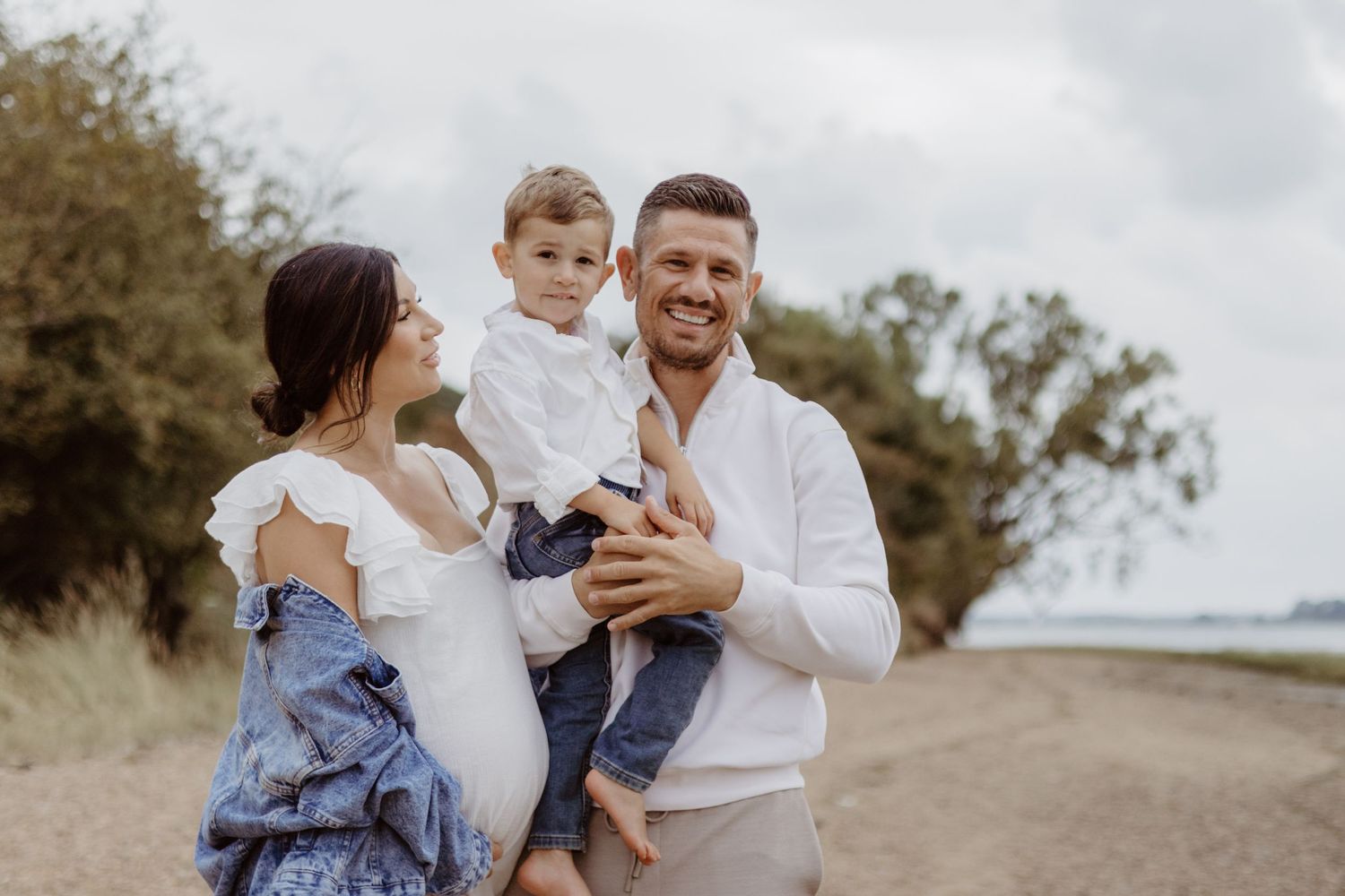 Candid family portrait showing joyful interactions in an outdoor field setting.