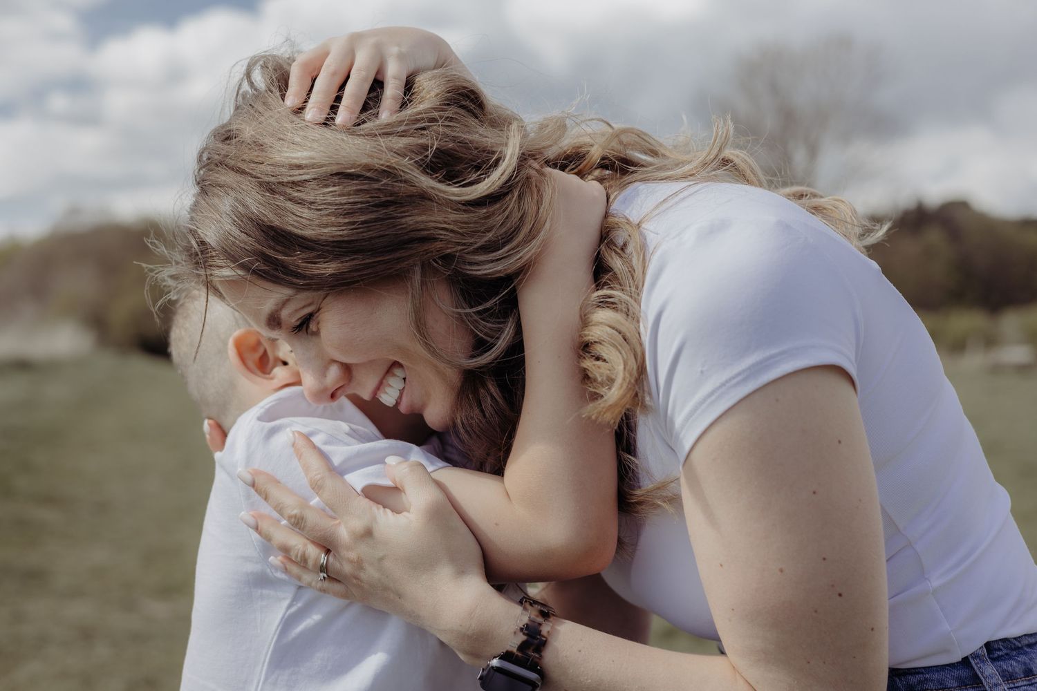 A tender moment of affection between parent and baby outdoors.