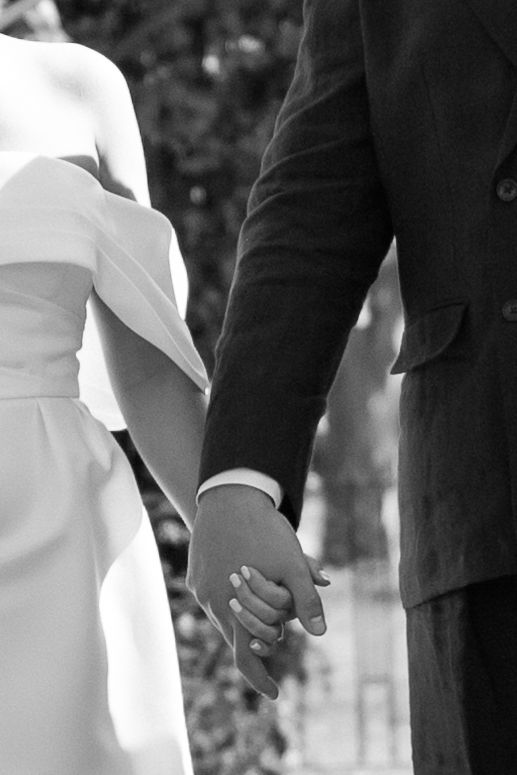 Close-up of bride and groom holding hands during wedding ceremony.