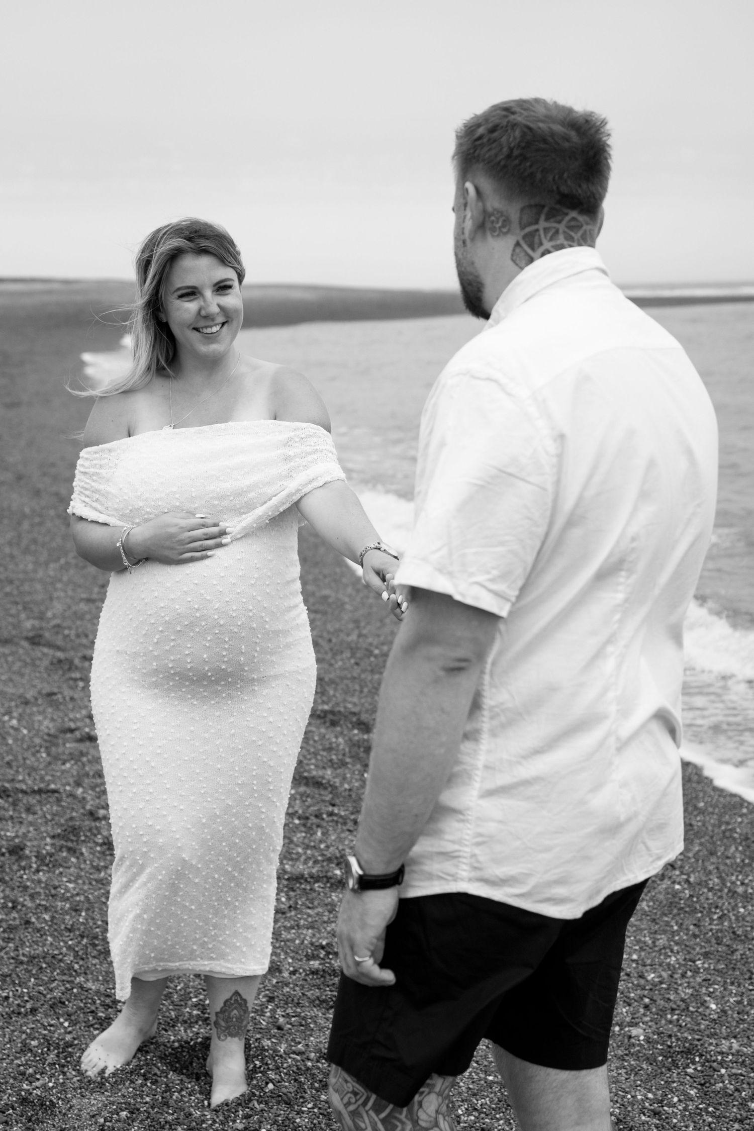 A romantic black and white photo series showing a couple walking together along a beach.