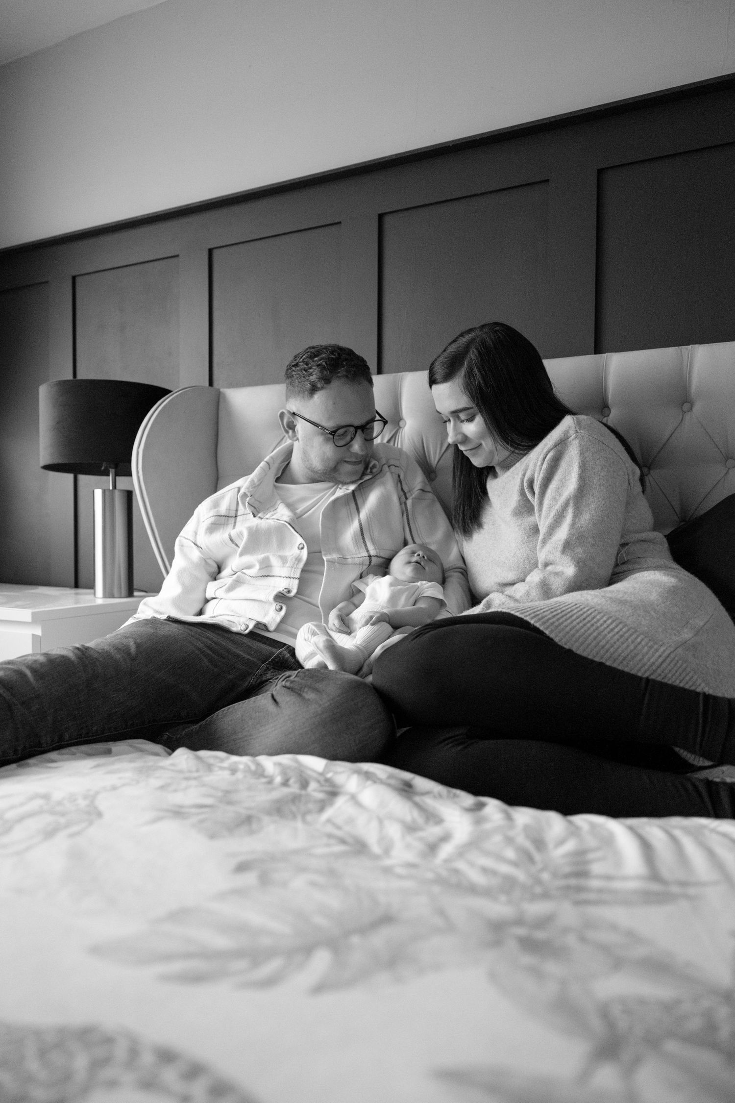A series of black and white photos showing someone reading in bed with changing positions and lighting.
