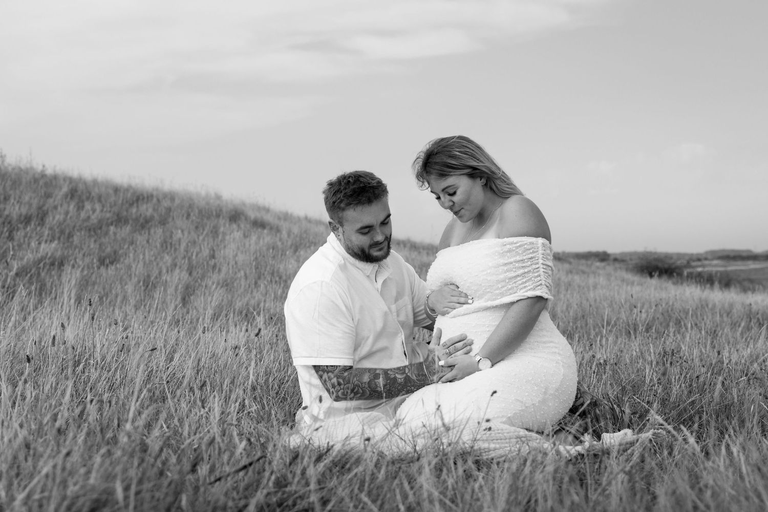 Candid moments of couple relaxing together in rural field setting.