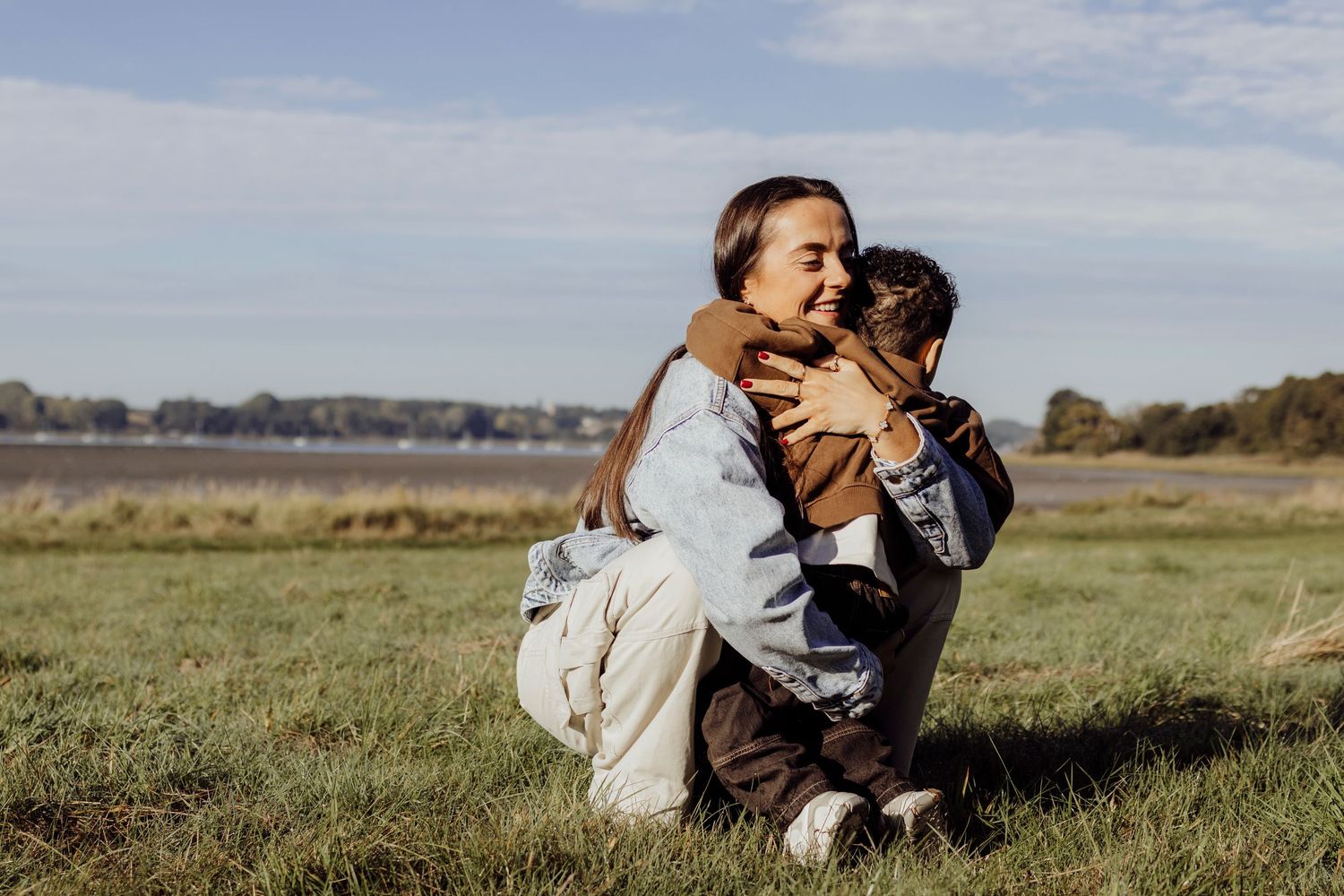 Candid outdoor photoshoot in a sunlit grassy field.