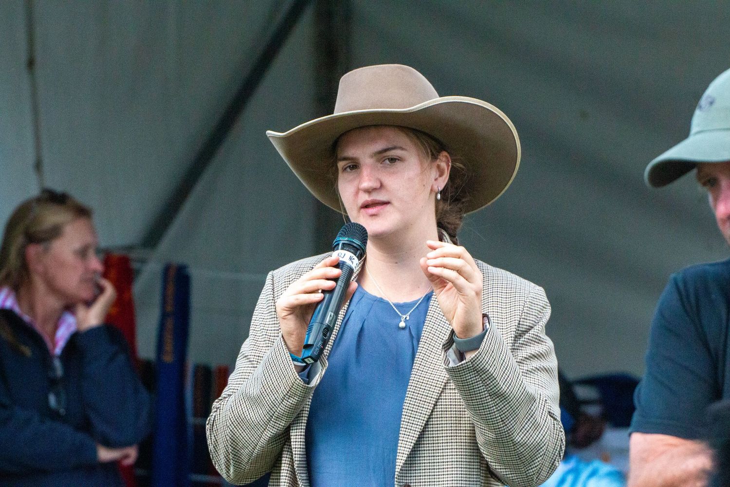 Competitors wearing cowboy hats and western attire at an equestrian competition.