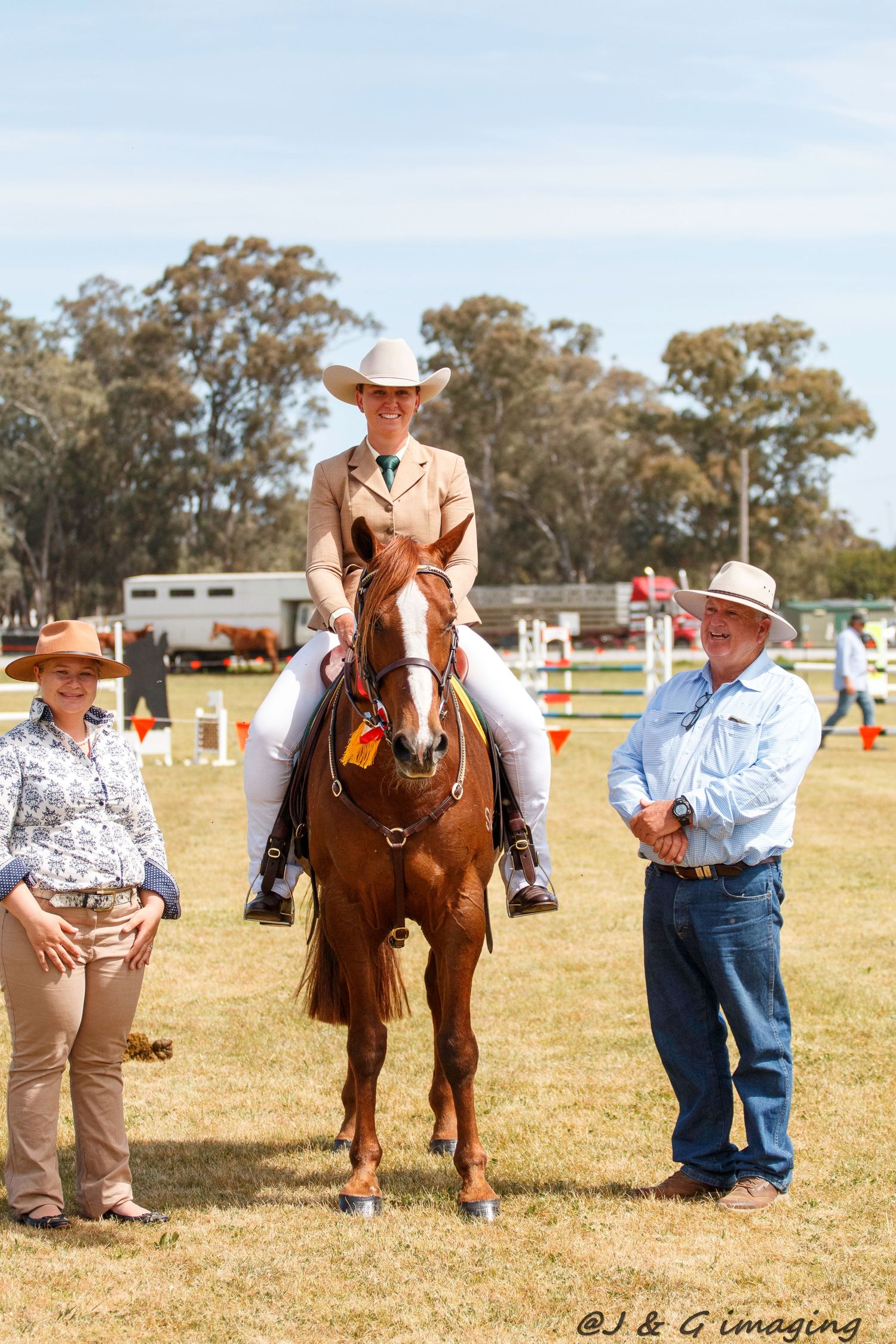 Spectators and handlers gather around horses at an outdoor equestrian competition.