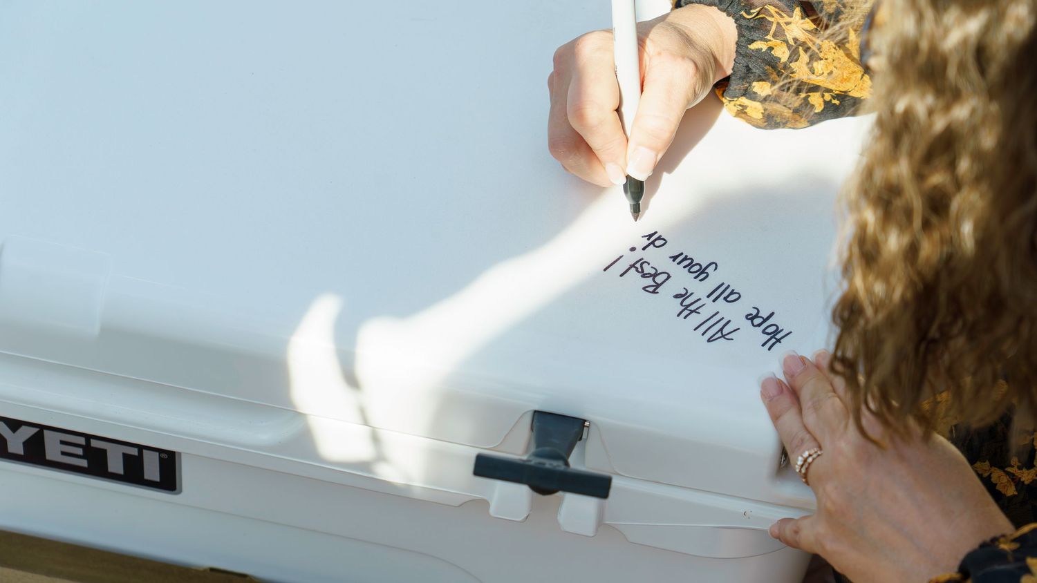 Close-up shot of hands writing on paper against a blurred background.