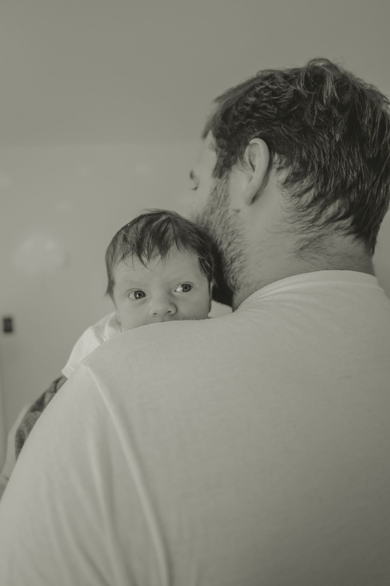 Family lifestyle session at home with dad and baby snuggling.