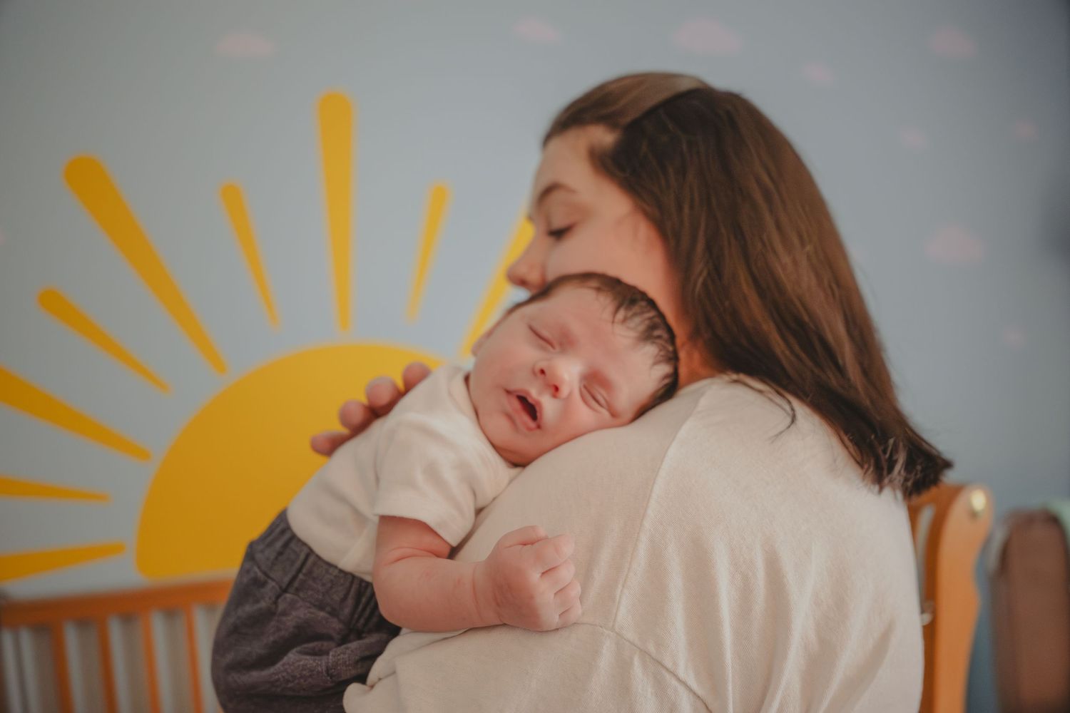 Family lifestyle session at home with mom and baby snuggling.