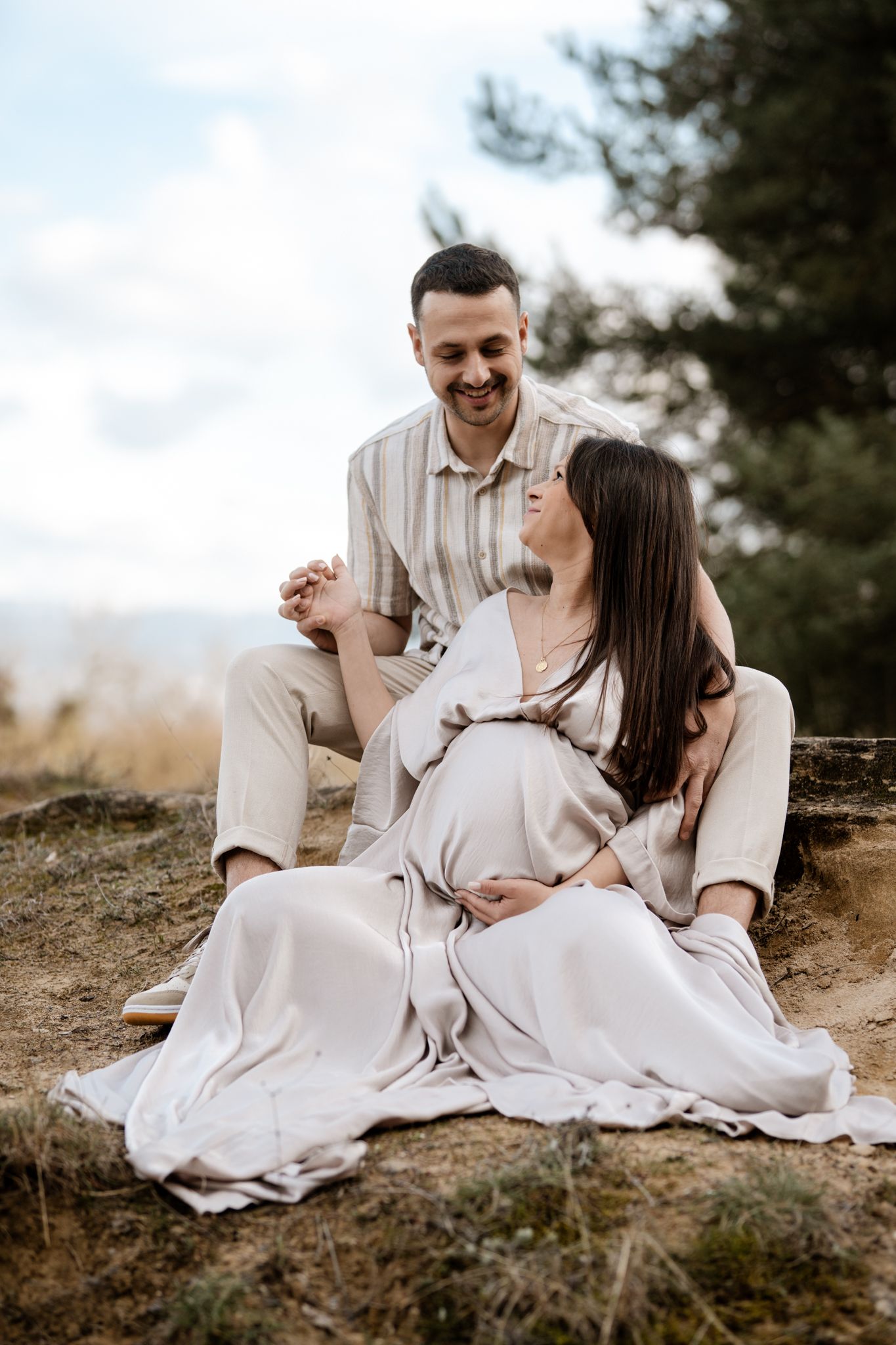Photo de grossesse en Isère : un couple radieux en pleine nature, célébrant l'attente de leur bébé avec tendresse.