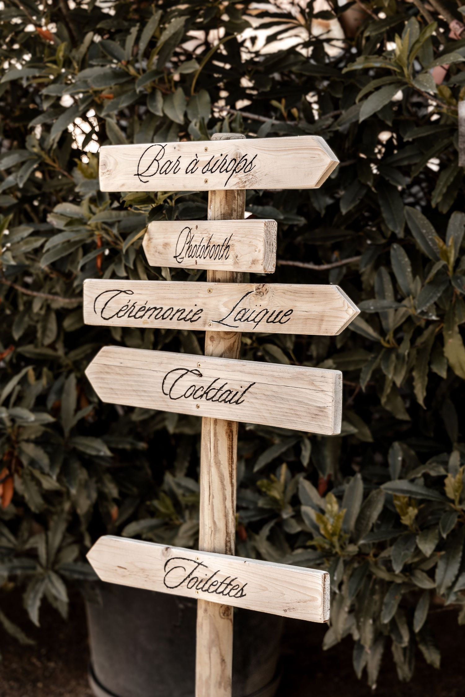 Rustic wooden wedding directional sign with French labels for bar, photobooth, ceremony, cocktail, toilets.