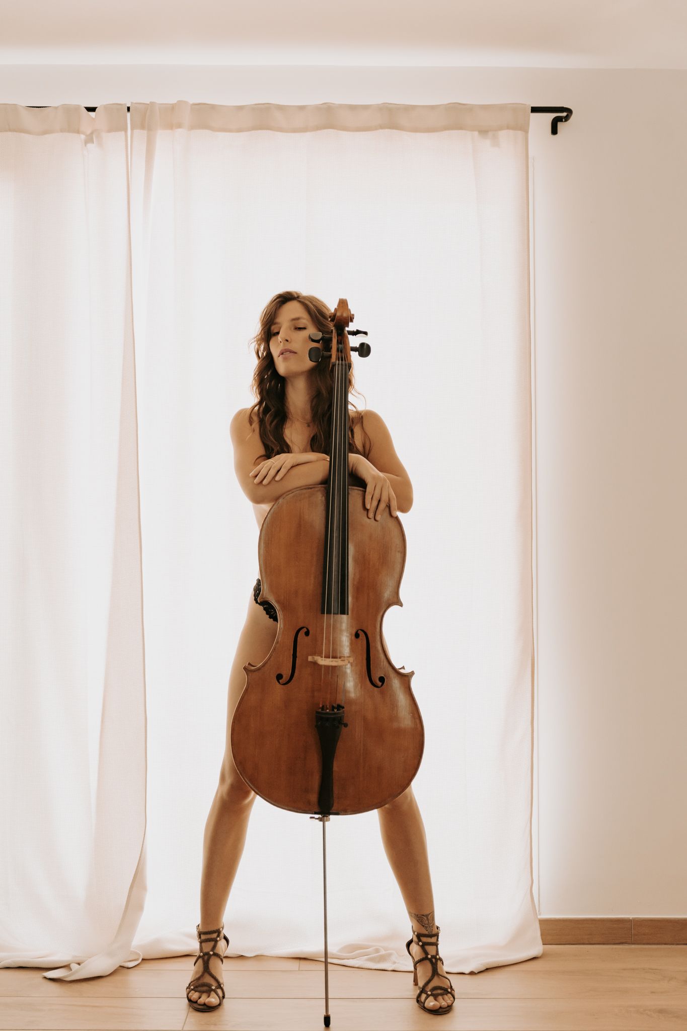 Séance photo boudoir en Isère : l'élégance artistique d'un portrait intime au violoncelle en lumière naturelle.