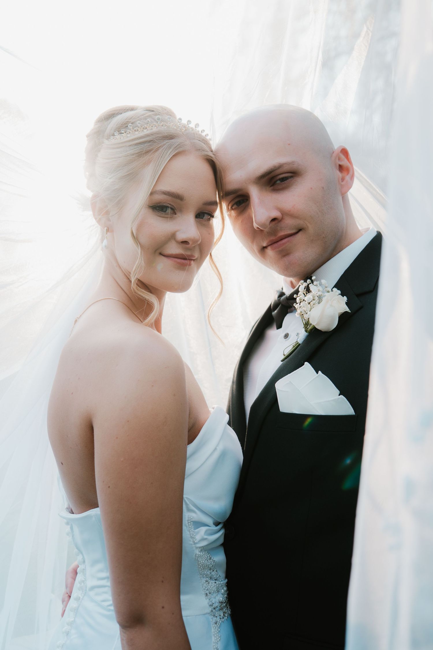 Intimate wedding portrait with soft lighting and elegant formal attire.