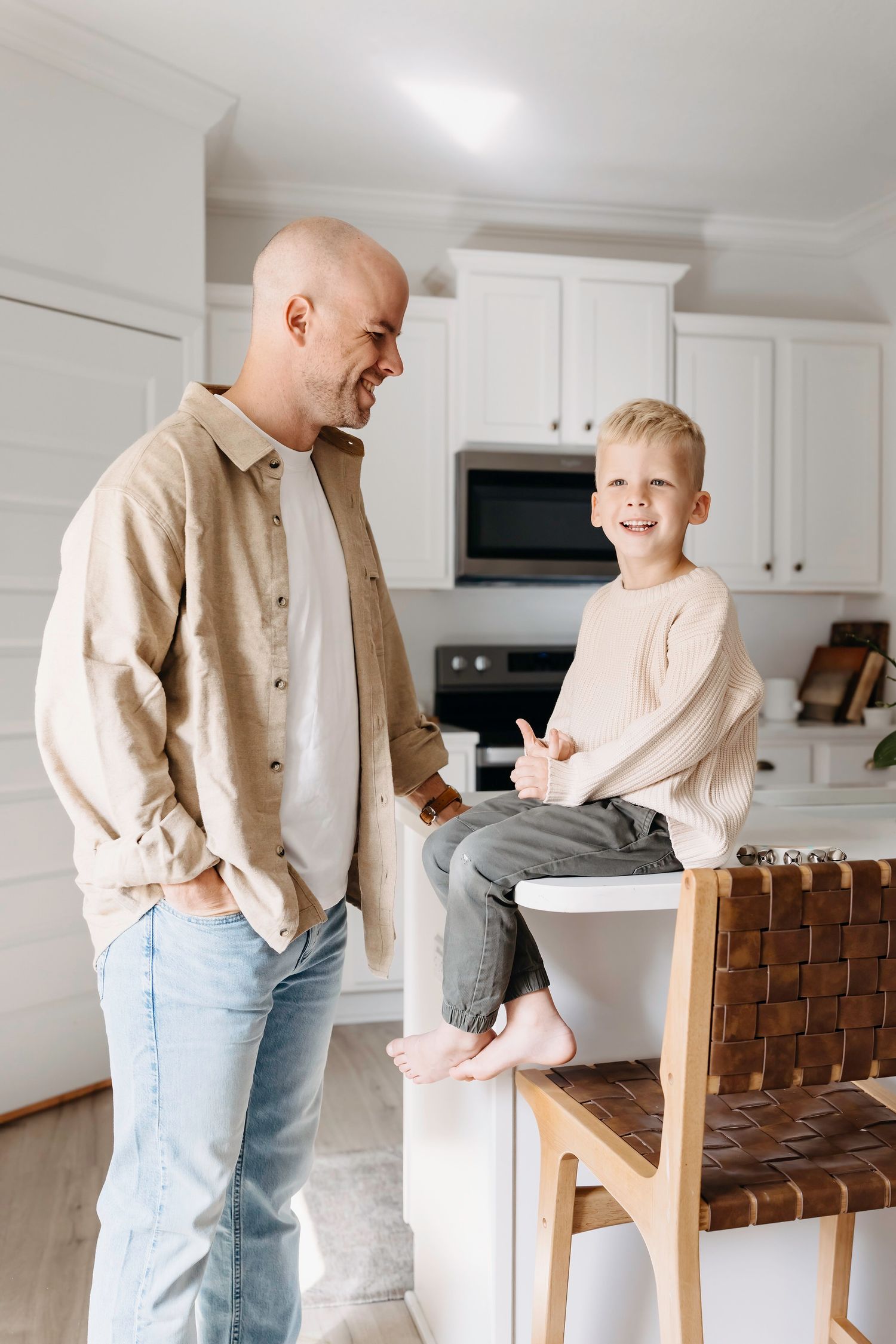 father and son hanging on in a well lit kitchen