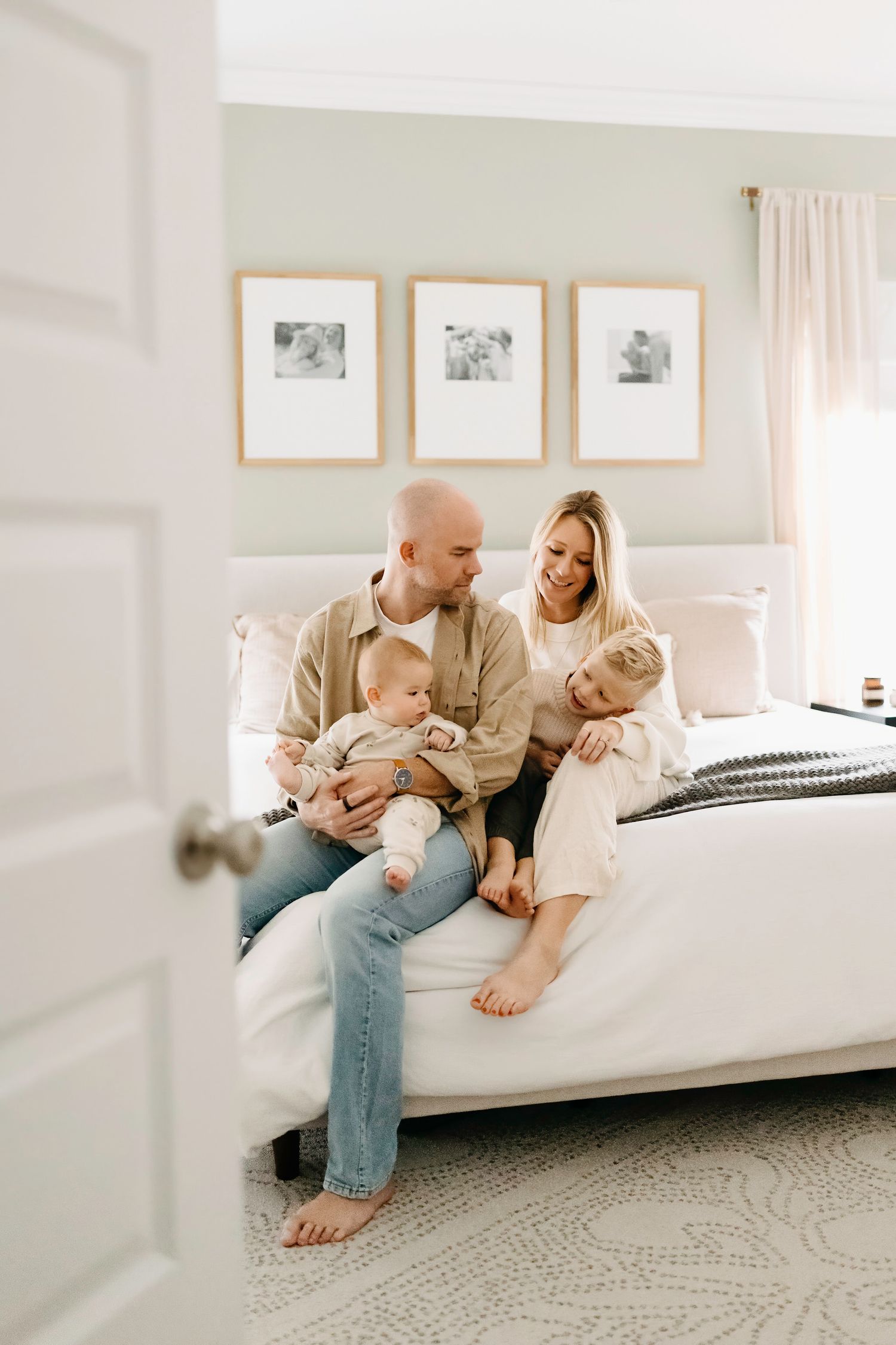 Family relaxing together on a white couch in a minimalist modern room.