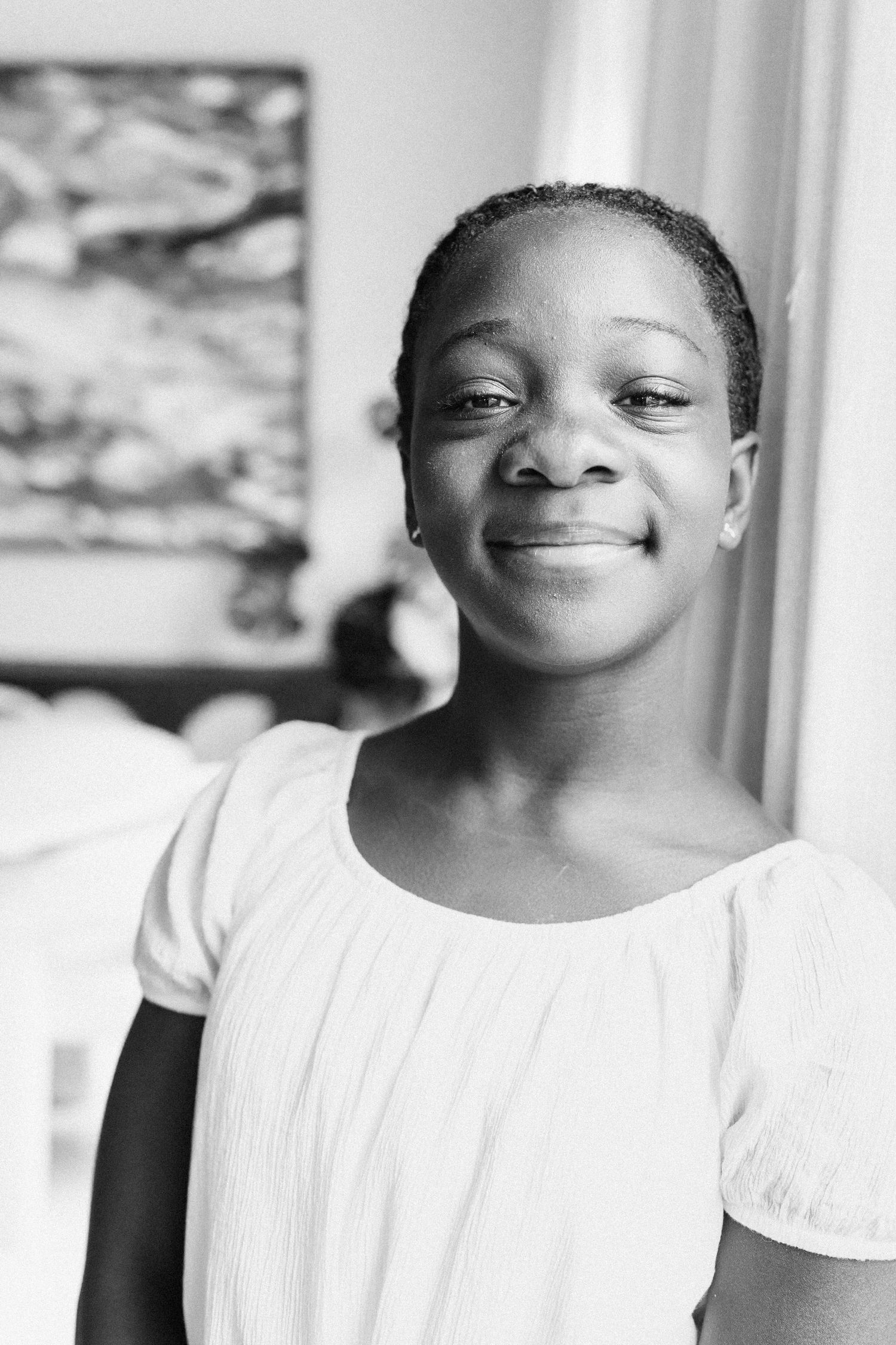 A series of black and white portraits showing joyful expressions and warm smiles against a light background.